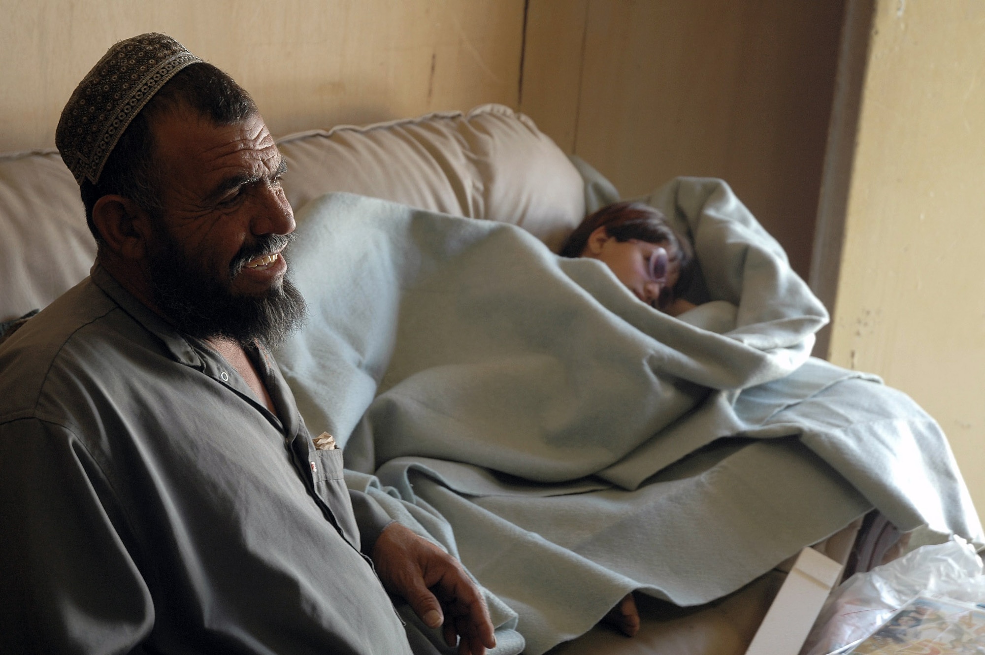 Abdullah Haqim, father of 6-year-old, Gulzana, smiles as he talks of her condition to a U.S. Special Forces doctor at Bagram Air Field, Afghanistan on July 10. Coalition doctors treated Gulzana for a tumor over her eye -- an affliction that has an extremely low chance of survival in Afghanistan if not treated properly. (U.S. Army photo/Sgt. Daniel Love)
