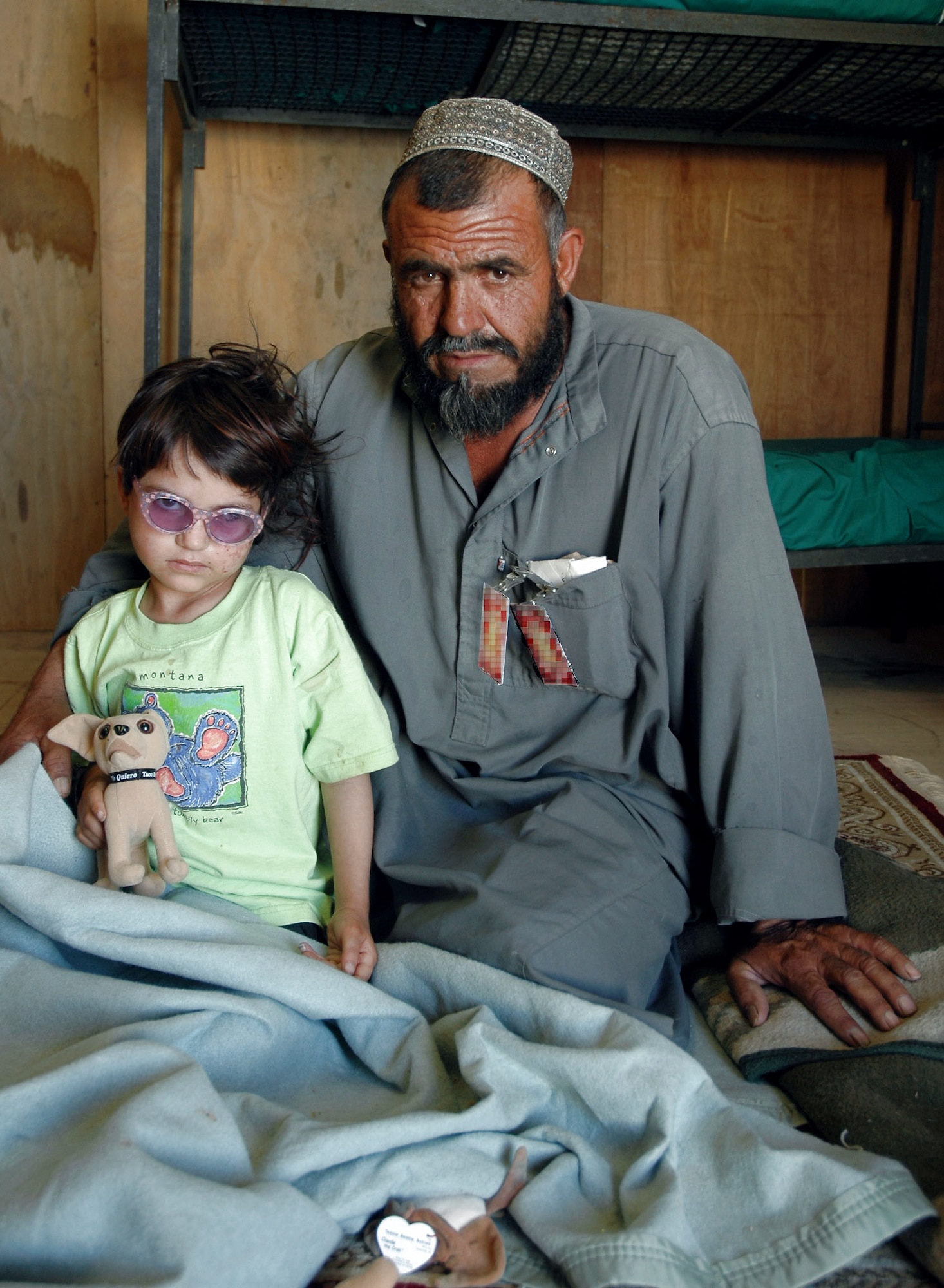 Gulzana Haqim and her father, Abdullah, pose for a photo July 11 during her recovery period at Bagram Air Field, Afghanistan. Gulzana was diagnosed with a tumor over her eye -- an affliction that has an extremely low chance of survival in Afghanistan if not treated. (U.S. Army photo/Sgt. Daniel Love) 