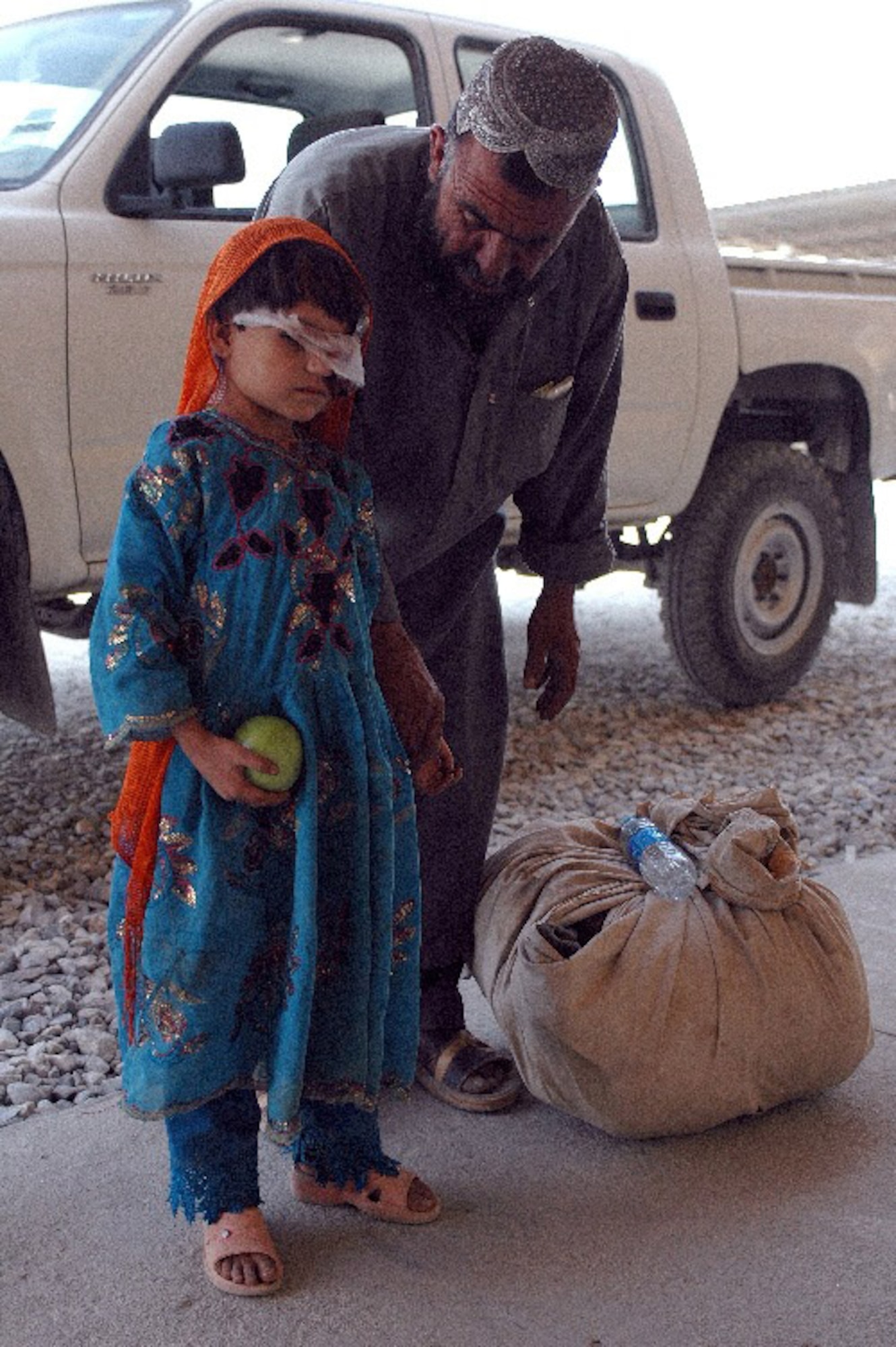 Gulzana Haqim, a 6-year-old Afghan girl, and her father, Abdullah, arrive at Bagram Air Field, Afghanistan, July 9. Gulzana was treated for a tumor over her eye at Craig Joint Theater Hospital on Bagram, where her eye and possibly her life was saved by Coalition doctors. (U.S. Army photo/Sgt. Daniel Love) 
