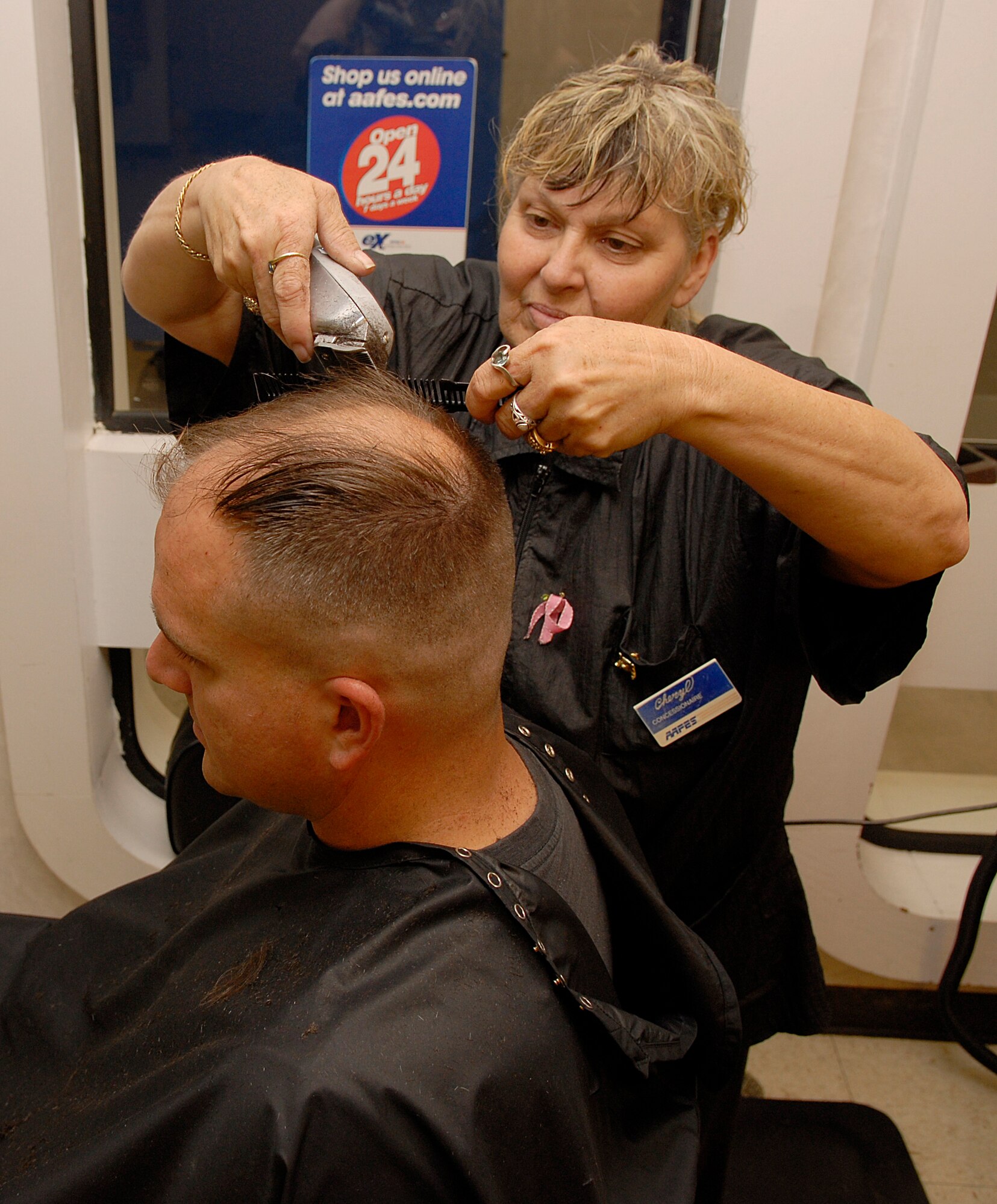 VANDENBERG AIR FORCE BASE, Calif. --  Cheryl Davis, manager of the Vandenberg Barber Shop, gives a haircut to  Staff Sgt. Kristopher Powell, 576th Training Squadron, Monday here.  (U.S. Air Force photo/Airman 1st Class Andrew Satran)
