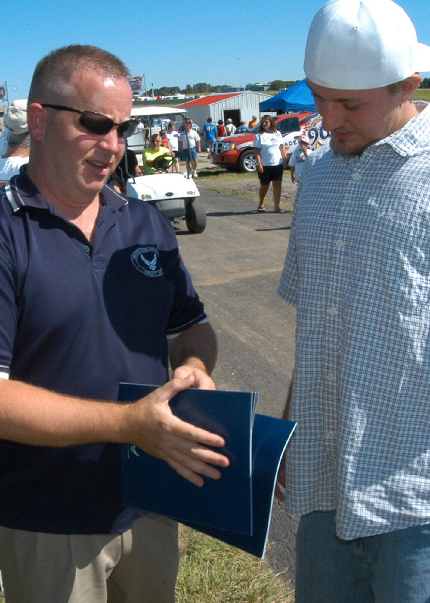 Staff Sgt. Robert Bryant, 343rd Recruiting Squadron, shares information with a potential applicant during Air Force Night July 12 at I-80 Speedway in Greenwood, Neb. The event was highlighted by the homecoming of Carl Edwards, the driver of the No. 99 Office Depot car in the NASCAR Sprint Cup Series. Mr. Edwards took time to shake hands and sign autographs for attending Air Force members. (U.S. Air Force photo/Staff Sgt. David McCarrison)