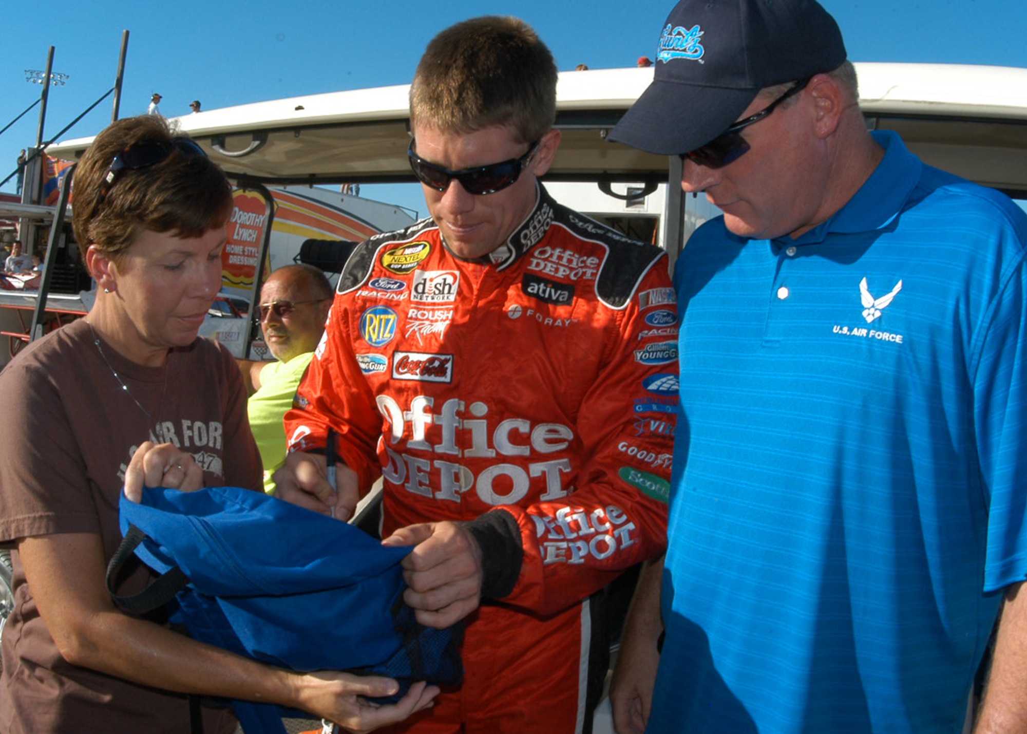 Carl Edwards, driver of the No. 99 Office Depot car in the NASCAR Sprint Series, signs a backpack July 12 for Senior Master Sgt. Mark Granger, 343rd Recruiting Squadron senior trainer, and his wife, Tech. Sgt. Carol Granger, 55th Medical Operations Squadron, Offutt Air Force Base, during Air Force Night at I-80 Speedway in Greenwood, Neb. During Mr. Edwards’s visit of his home track, he signed autographs and posed for pictures with Air Force members. (U.S. Air Force photo/Staff Sgt. David McCarrison)