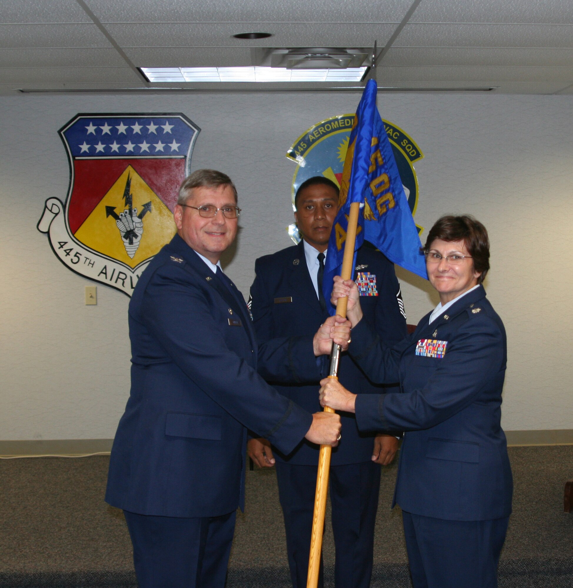 WRIGHT-PATTERSON AFB, Ohio - Col. Roger Gallet, 445th Operations Group commander, passes the 445th Aeromedical Evacuation Squadron guidon to incoming commander, Lt. Col. Linda Stokes-Crowe July 12, 2008. Aeromedical Evacuation Squadron First Sergeant, Master Sgt. James Felton, assists during the ceremony. (U.S. Air Force photo/Staff Sgt. Martin Moleski)
