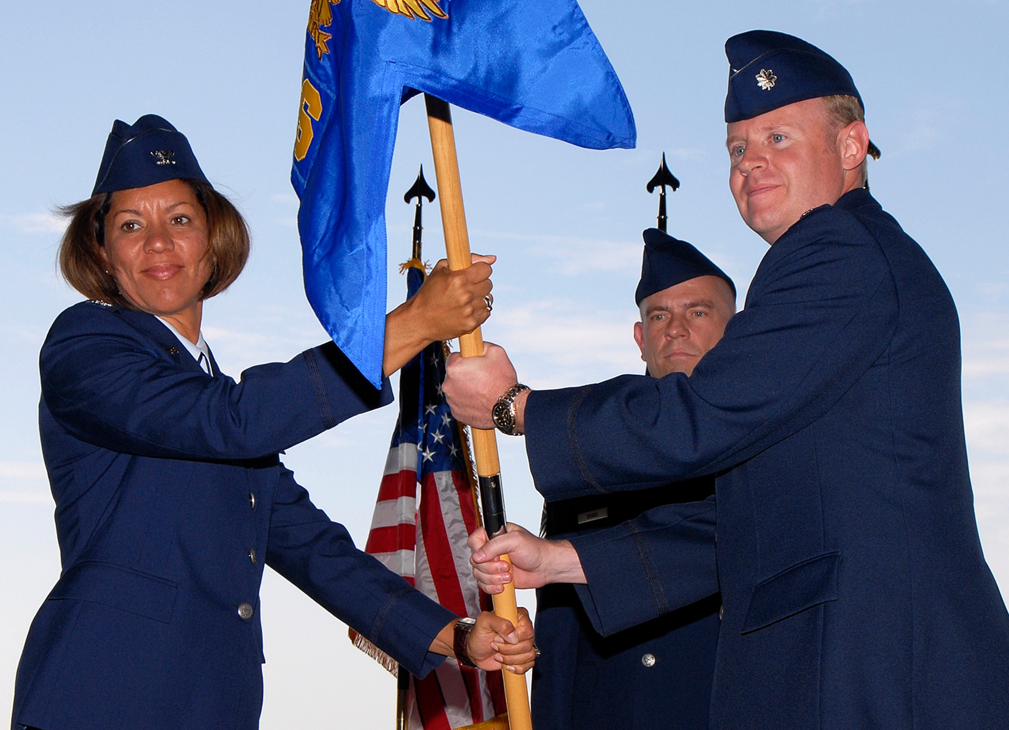 Col. Emily Buckman and Lt. Col. Robert Romer pass the new unit guideon July 15 in Hangar 119, officially activating the new 21st Force Support Squadron at Peterson Air Force Base, Colo. The unit’s stand up official marks the consolidation of both the 21st Mission Support and Service Squadrons. The consolidation supports the Air Force Chief of Staff’s Air Force Smart Operations-21 initiative. (U.S. Air Force photo/Craig Denton)