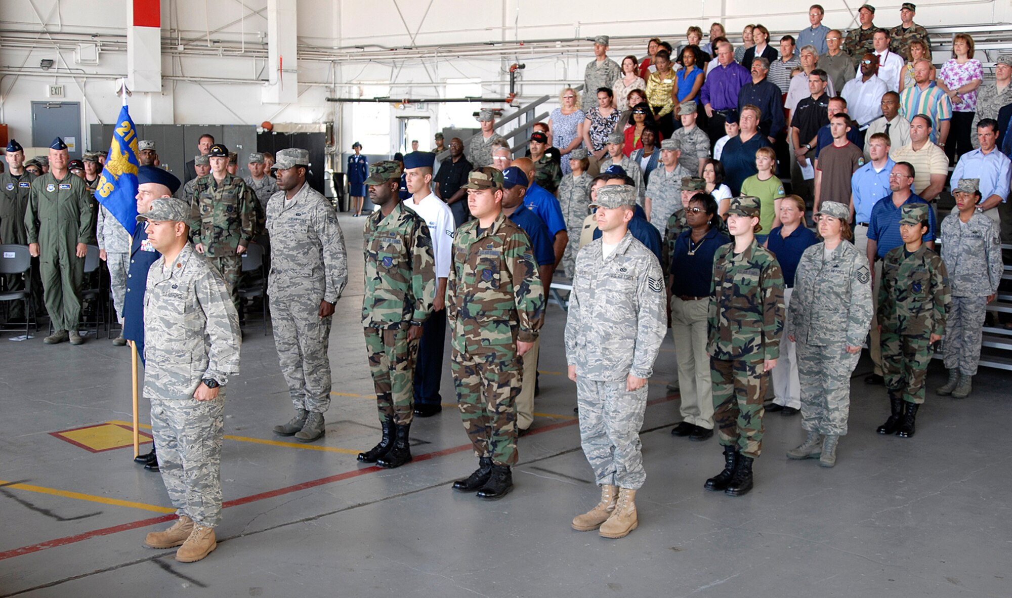 Airmen and guests stand at attention during the 21st Force Support Squadron activation ceremony July 15 in Hangar 119 at Peterson Air Force Base, Colo. The unit’s stand up official marks the consolidation of both the 21st Mission Support and Service Squadrons. The consolidation supports the Air Force Chief of Staff’s Air Force Smart Operations-21 initiative. (U.S. Air Force photo/Roberta McDonald)
