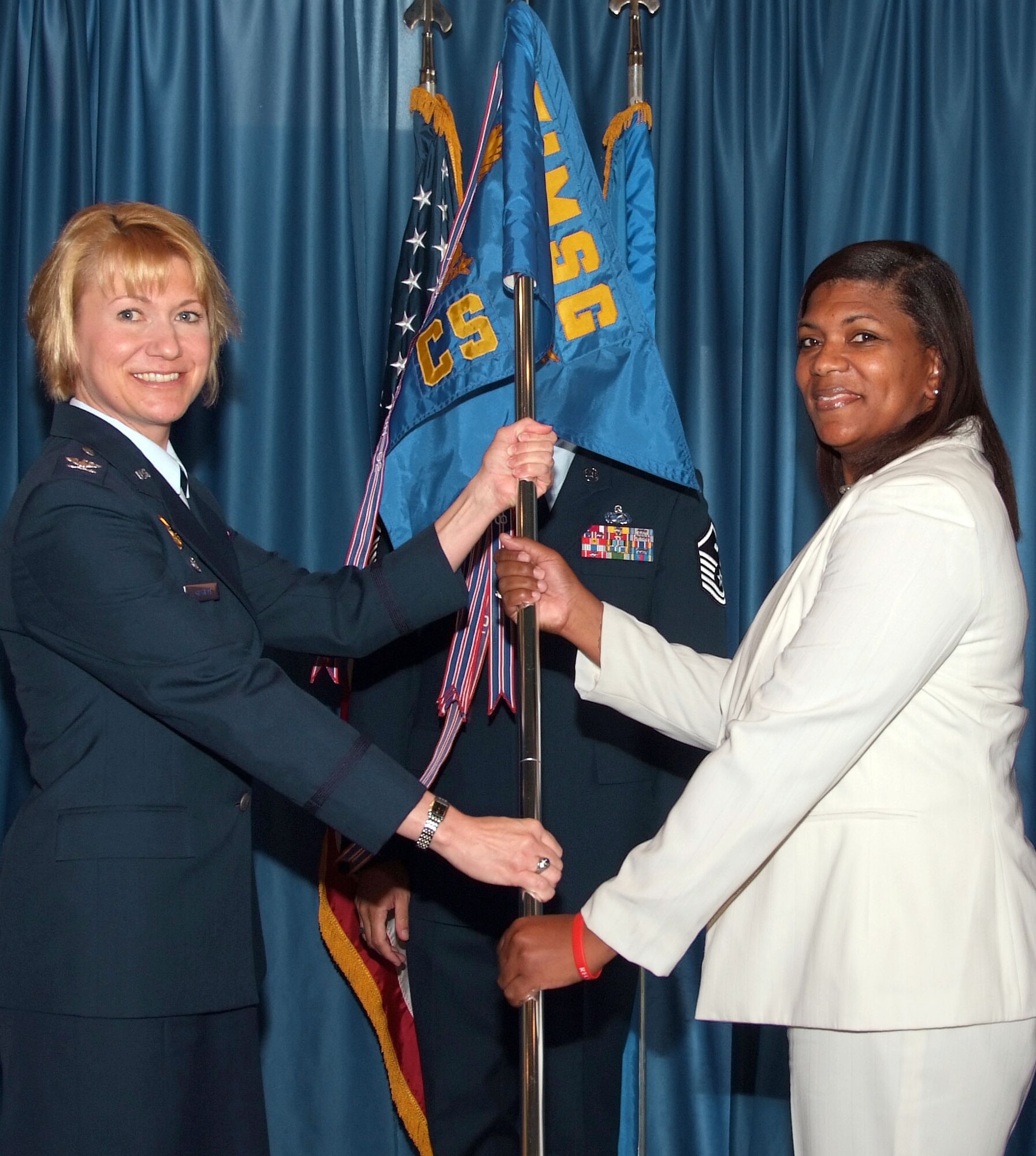 Ms. Cecily Odom, right, assumed leadership of the 71st Communications Squadron when she accepted the unit guidon from Col. Jennifer Graham, commander of the 71st Mission Support Squadron, during a ceremony Tuesday, July 15, at Vance AFB, Okla. (U.S. Air Force photo by Terry Wasson)