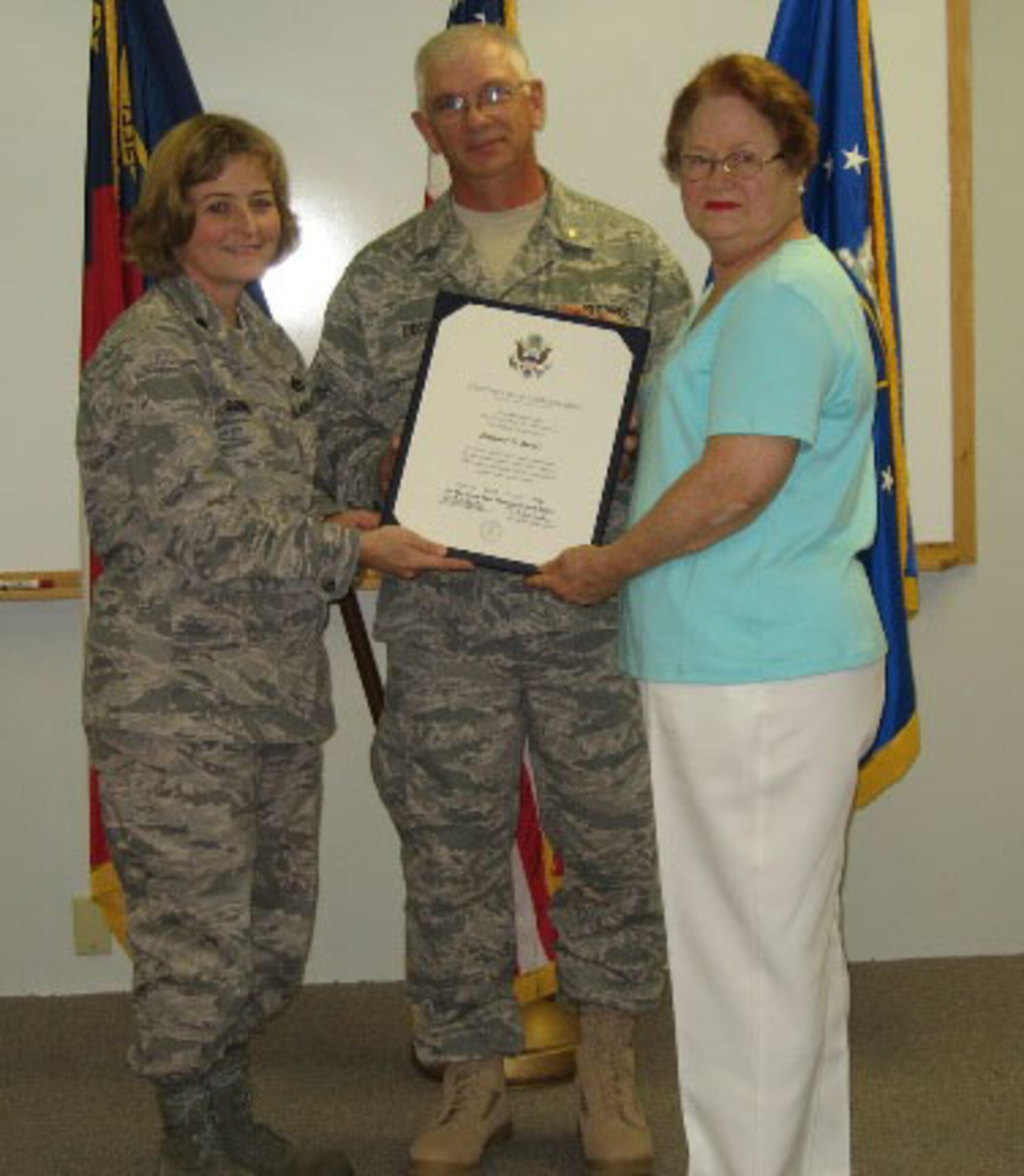 SEYMOUR JOHNSON AIR FORCE BASE, N.C. -- Eleanor Decot (right) receives a certificate of appreciation for supporting the Air Force Reserve during her husband's 23-year-career. Master Sgt. Danny Decot (center), retired from the 916th Civil Engineer Squadron as the non-commissioned officer in charge of liquid fuel systems maintenance. Lt. Col. Kerri Grimes, squadron commander, presented the awards.