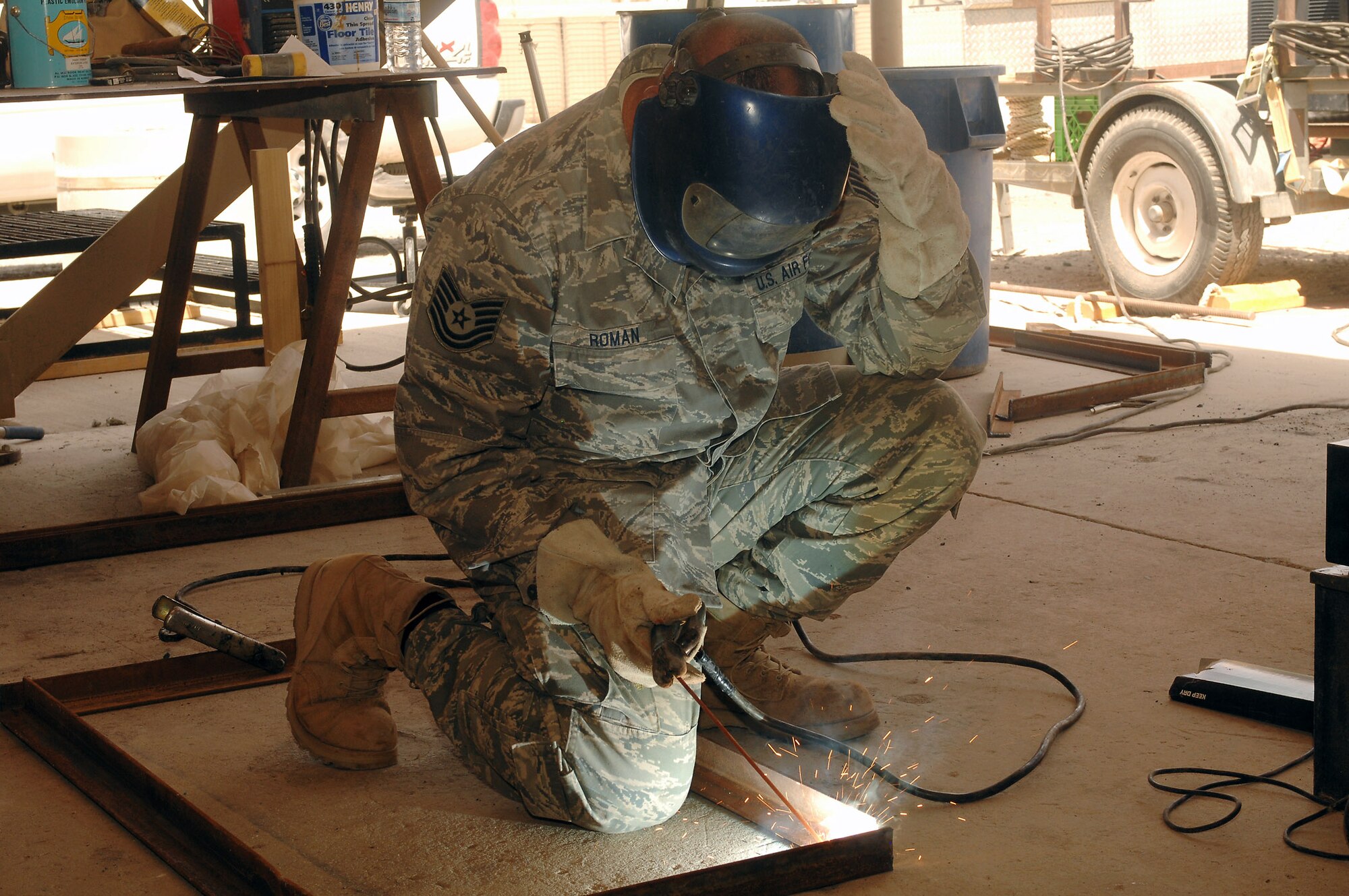 Sparks fly as Tech. Sgt. Anthony Roman, deployed to the 386th Expeditionary Civil Engineer Squadron, uses an arc welder to join a frame together on July 11 at a base in Southwest Asia. The 386th ECES is completing a project to increase the square footage of the K-9 kennels for the 386th Expeditionary Security Forces Squadron. The metal frames will be used to build new ramps for the facilities. Sergeant Roman is deployed from the 156th Airlift Wing, Muniz Air National Guard Base, Puerto Rico. (U.S. Air Force photo/Tech. Sgt. Raheem Moore) 

