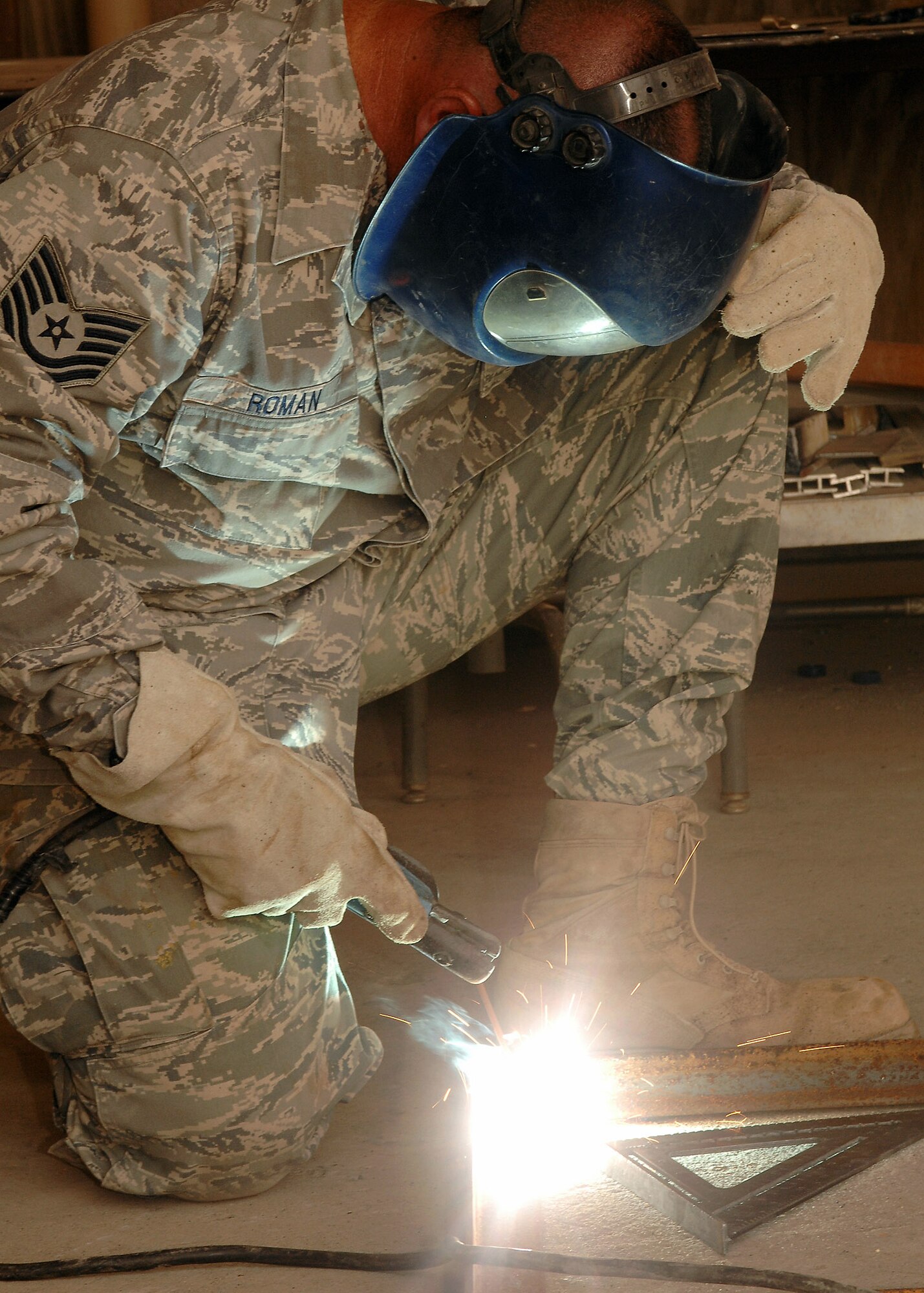 Sparks fly as Tech. Sgt. Anthony Roman, deployed to the 386th Civil Engineer Squadron, uses an arc welder to join a frame together on July 11 at a base in Southwest Asia. The Civil Engineer Squadron is completing a project to increase the square footage of the K-9 kennels for the 386th Expeditionary Security Forces Squadron. The metal frames will be used to build new ramps for the dogs. Sergeant Roman is deployed from the 156th Airlift Wing, Muniz Air National Guard Base, Puerto Rico. (U.S. Air Force photo/Tech. Sgt. Raheem Moore)