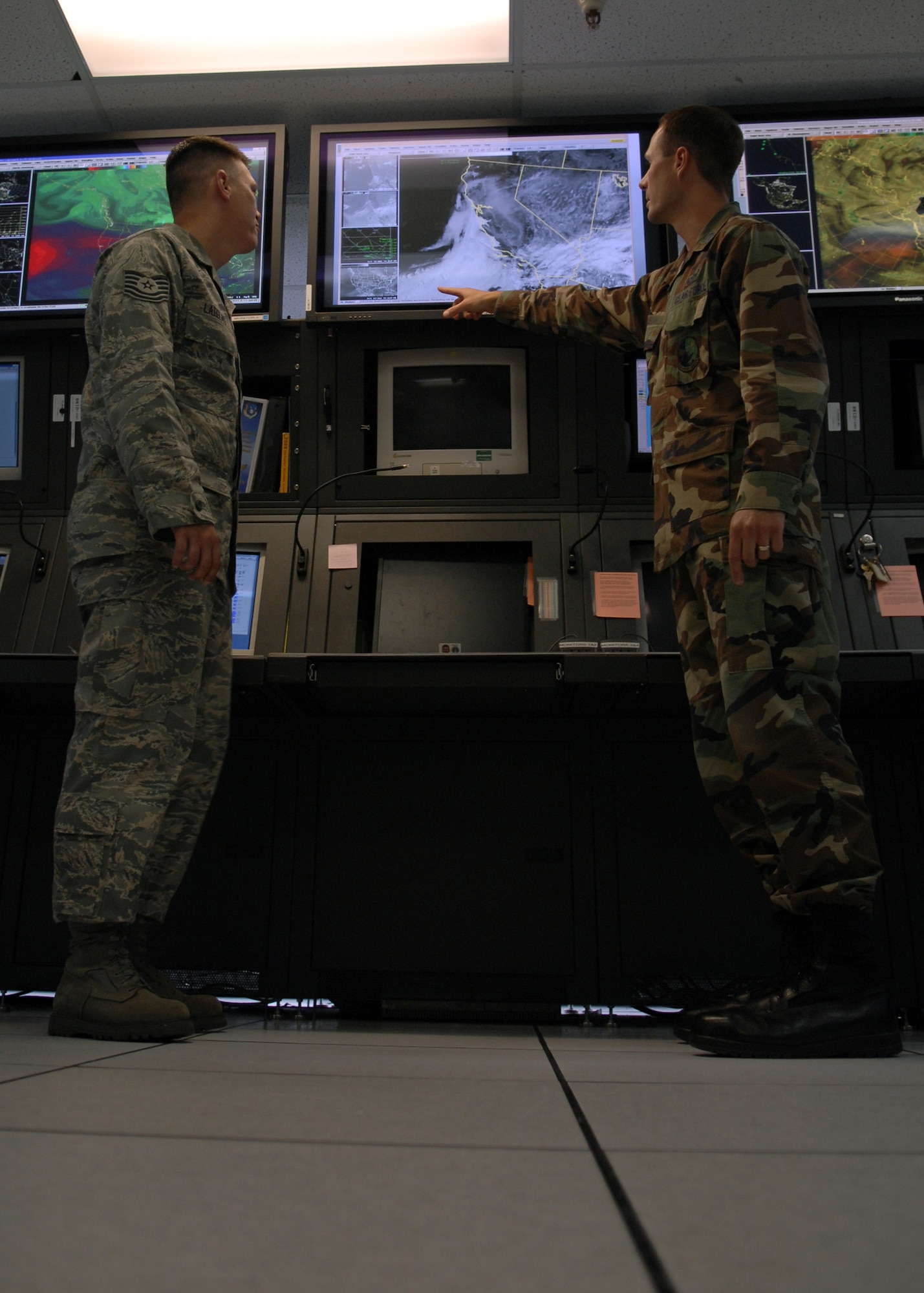 VANDENBERG AIR FORCE BASE, Calif. --  Tech. Sgt. Corey Latiolais, NCO in charge of weather station operations, and Capt. Jonathan Mason, a launch weather officer, both with the 30th Weather Squadron, go over weather data in the operations center here Friday. (U.S. Air Force photo/Airman 1st Class Andrew Satran)