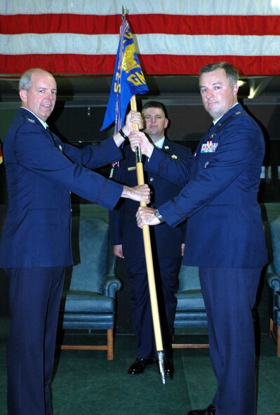 Col. Paul Judge, 571st Contingency Response Group commander, hands the 571st Global Mobility Squadron guideon to Lt. Col. Scott Zippwald, the new 571st GMS commander. Colonel Zippwald recently served as Chief, Strategic Airlift Branch, Directorate of Global Reach Programs, Pentagon, where he was responsible for managing and providing oversight to both the C-17 Globemaster and C-5 Galaxy acquisition programs. Colonel John Hamuka will become the deputy group commander for the 515th AMOG at Yokota Air Base, Japan. (U.S. Air Force photo/Airman 1st Class Kristen Rohrer)