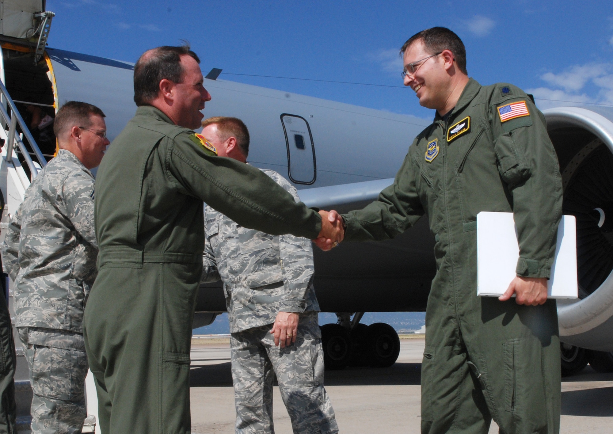 Col. Al Hunt, 375th Airlift Wing commander (left), greets Lt. Col. Bryan Miller July 15 after landing at Peterson Air Force Base, Colo. Colonel Hunt, together with members of the 375th AW, are leading a tour of St. Louis-area civic leaders to Peterson of several units, including the host unit, the 21st Space Wing, the 302nd Airlift Wing and the 311th Airlift Squadron. The squadron, a geographically-separated unit assigned to the 375th AW, operates the C-21A, an aircraft that provides time-, place- and mission-sensitive airlift of personnel and cargo during times of war, peace and in support of emergencies. Colonel Miller is the 311st AS director of operations. (U.S. Air Force photo/Senior Airman Stephen Collier)