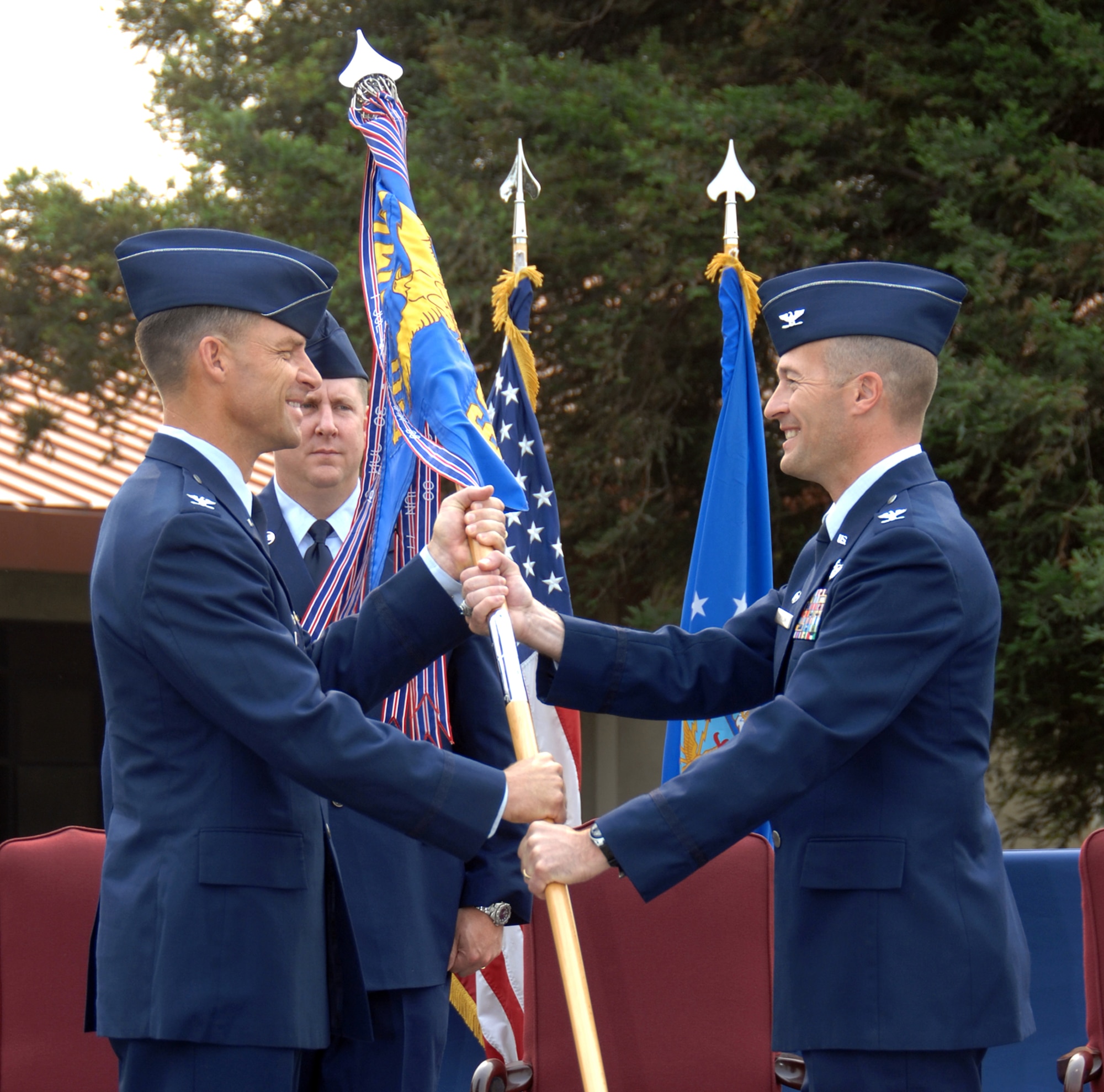 Col. Mark Dillon, 60th Air Mobility Wing commander, hands the 60th Mission Support Group Guideon to Col. James Spaulding during a change-of-command ceremony July 10 in front of 60th AMW headquarters. (U.S. Air Force photo/ Nan Wylie)