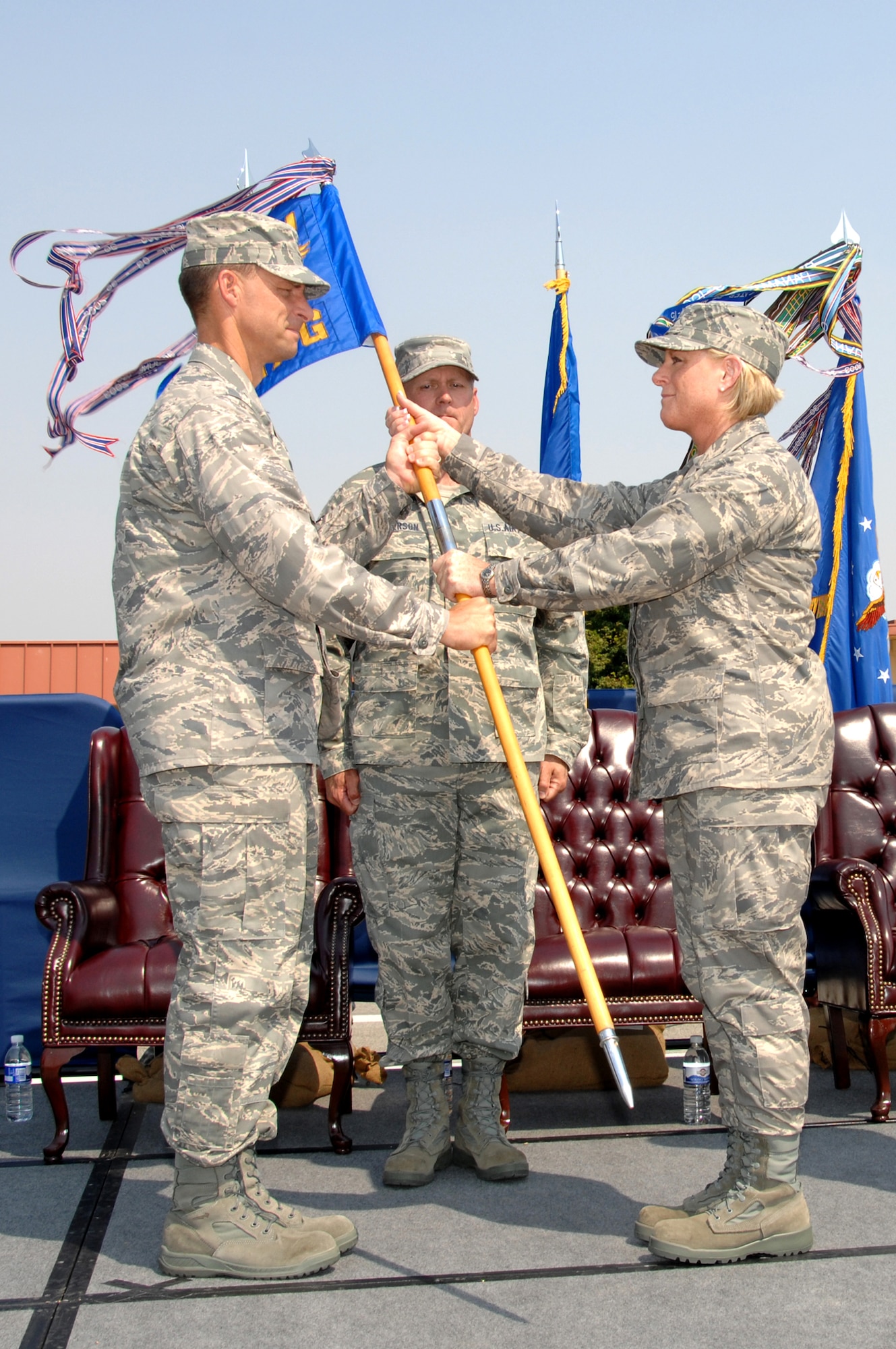 Col. Mark Dillon, 60th Air Mobility Wing commander, hands the 60th Maintenance Group guideon to Col. Carol Johnson, the new 60th MXG commander during a change-of-command ceremony July 8 on the flightline. (U.S. Air Force photo/Nan Wylie)