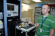 Michael Hunt prepares to test a decoder assembly from an A-10 Thunderbolt II using the new Versatile Depot Automatic Test Station.  The new system is a significant improvement over the older systems currently being used at Air Force depots.  Mr. Hunt is a Warner Robins Air Logistics Center lead test station operator at Robins Air Force Base, Ga.  (U.S. Air Force photo/Claude Lazzara)