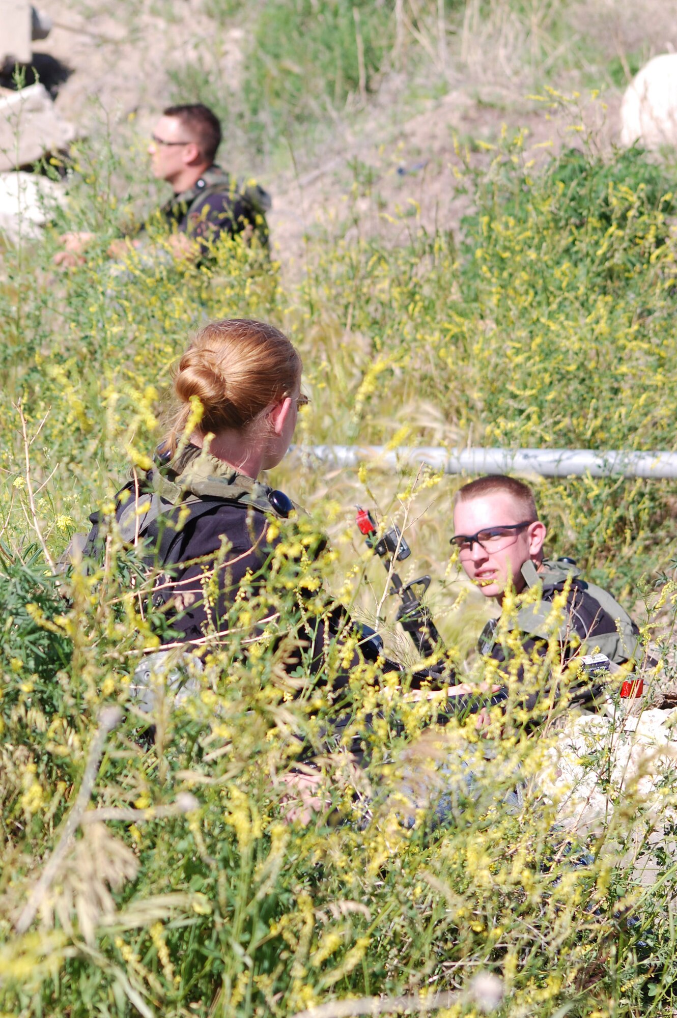 Role-players in an exercise wait patiently in the rubble and weeds near Camp Grizzly July 10. The exercise simulated what would happen in the event of an internal threat to the weapon system. (U.S. Air Force photo/Airman 1st Class Emerald Ralston) 