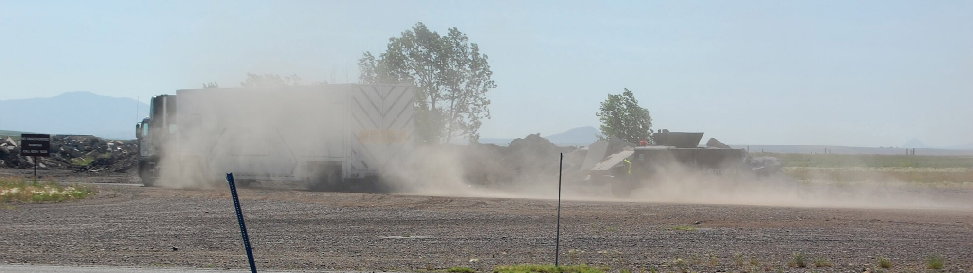 A payload transporter speeds through a gravel opening after two rouge maintainers hijack the vehicle containing a weapon component in an exercise here July 10. The exercise simulated response to an internal threat to the weapon system. (U.S. Air Force photo/Airman 1st Class Emerald Ralston)