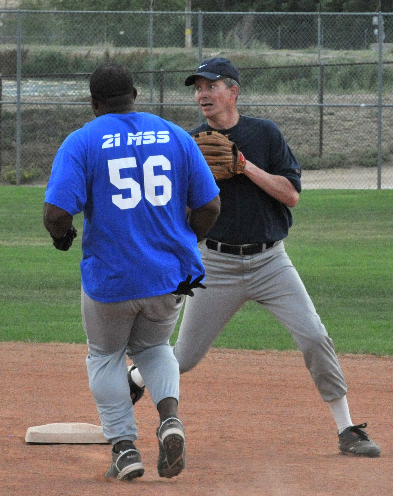 U.S. Northern Command J34’s shortstop, back, looks to fire home after forcing a 21st Mission Support Squadron runner during softball action July 10 at the Peterson Sports and Fitness softball complex. (CSMNG photo/Walt Johnson)
