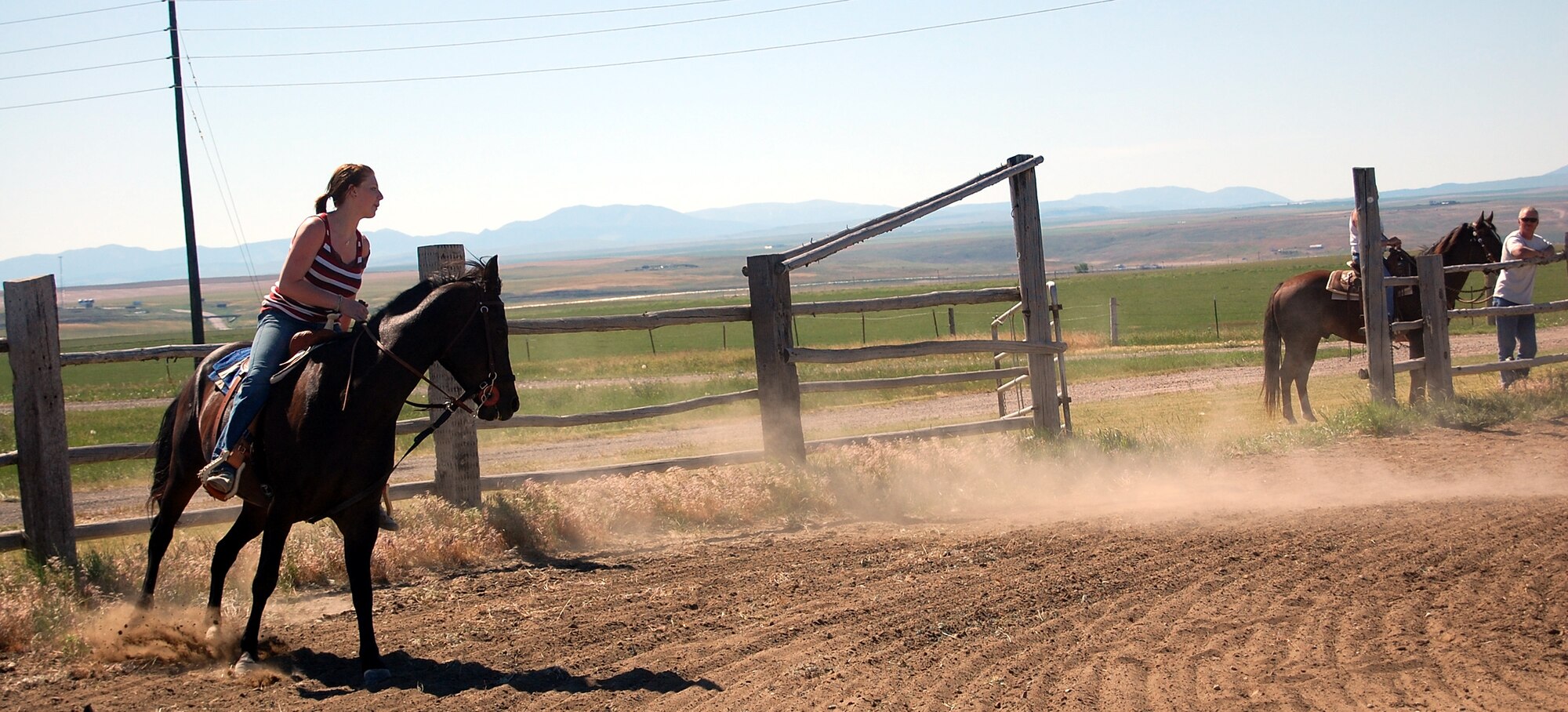 Tanya Giffin and her horse, Hank, cross the finish line after completing a timed barrel race during the first Malmstrom Rider's Club rodeo July 12. Ms. Griffin said she has riden horses all her life and she has been at Malmstrom about a year. (U.S. Air Force photo/Valerie Mullett)