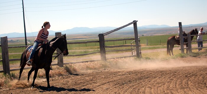 Tanya Giffin and her horse, Hank, cross the finish line after completing a timed barrel race during the first Malmstrom Rider's Club rodeo July 12. Ms. Griffin said she has riden horses all her life and she has been at Malmstrom about a year. (U.S. Air Force photo/Valerie Mullett)