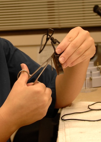 Airman 1st Class Meghan Mayhew trims a mouth guard for a Team Charleston member at the 437th Aerospace Medicine Squadron Deily Dental Clinic on Charleston AFB July 14. The use of mouth guards is recommended when playing any sport to protect the jaw, mouth and other tissues.  (U.S. Air Force photo/Airman 1st Class Katie Gieratz)