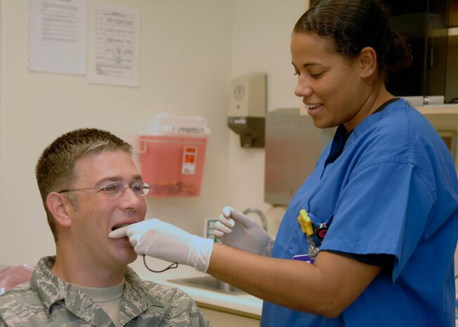 Senior Airman Stephanie Bernique-Garcia tests the fit of a sports guard with Tech. Sgt. Fred Hearn at the 437th Aerospace Medicine Squadron Deily Dental Clinic at Charleston AFB July 14. The use of mouth guards is recommended when playing any sport to protect the jaw, mouth and other tissues. Airman Bernique-Garcia is a dental assistant and Sergeant Hearn is a dental lab technician.  (U.S. Air Force photo/Airman 1st Class Katie Gieratz)