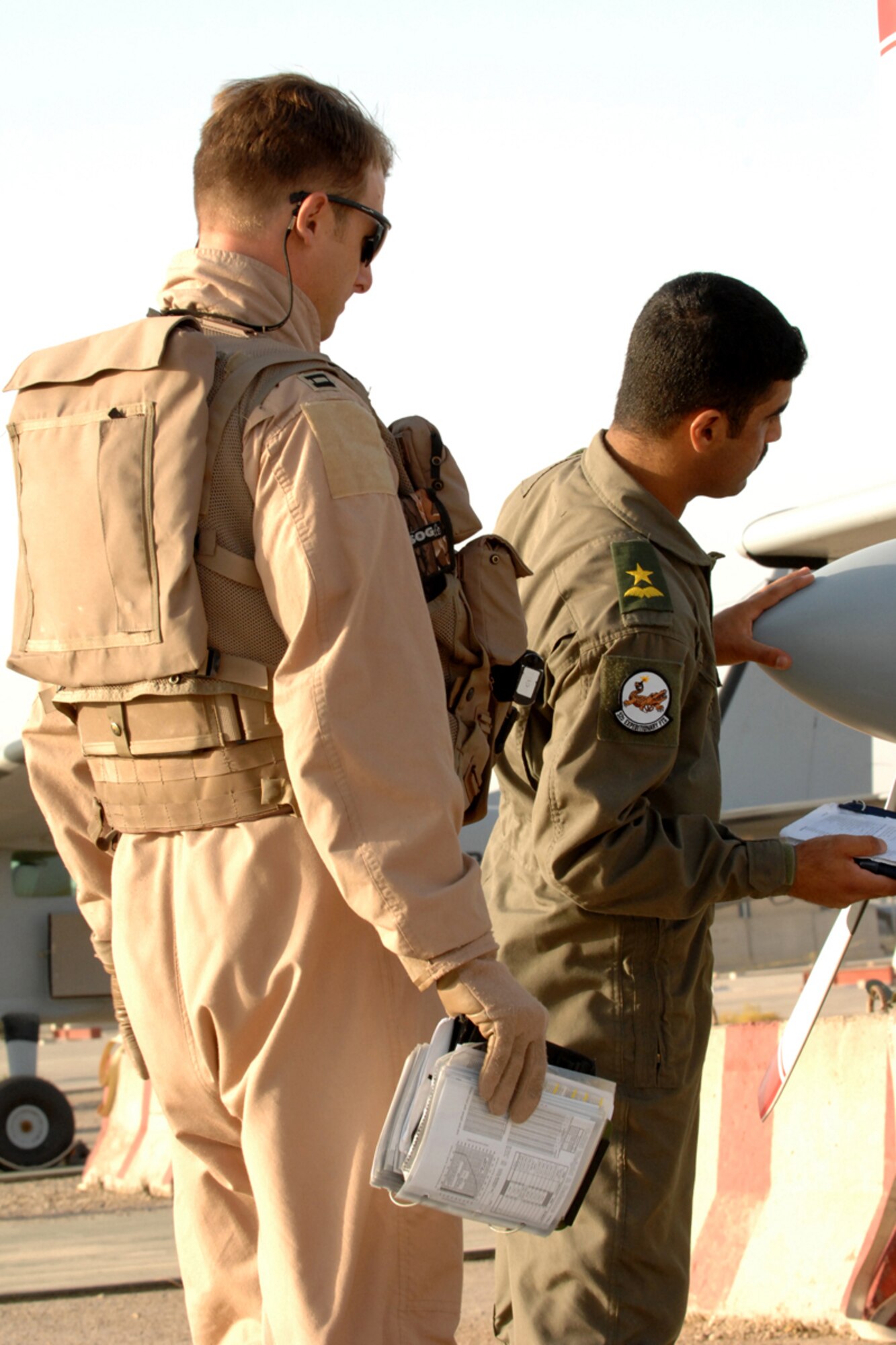 KIRKUK REGIONAL AIR BASE, IRAQ -- Capt. Jamie Riddle, 52nd Expeditionary Flying Training Squadron Instructor Pilot, and Lt. "Joseph," Iraqi Air Force Training Pilot, perform a preflight inspection of the Cessna 172 engine and propeller before a training flight mission here July 13. Their flight marked the 2,000th flying training hour milestone for the 52 EFTS and the IqAF. The 52 EFTS mission is to train, educate and advise the IqAF to build a institutional capacity to conduct credible fixed and rotary wing flight training for tomorrow. Capt. Riddle is deployed from Colombus Air Force Base, Miss.(U.S. Air Force photo/Airman First Class Randi Flaugh)