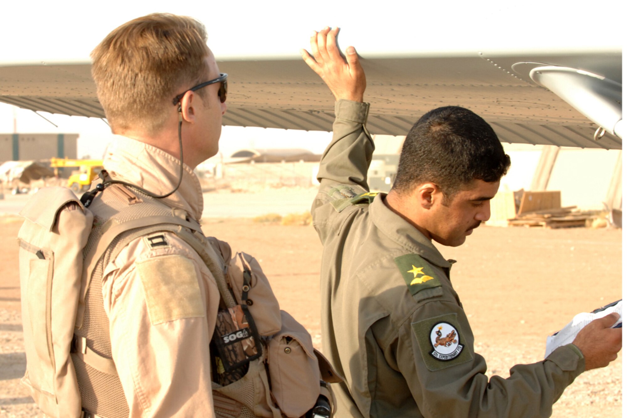 KIRKUK REGIONAL AIR BASE, IRAQ -- Capt. Jamie Riddle, 52nd Expeditionary Flying Training Squadron Instructor Pilot and Lt. "Joseph," Iraqi Air Force Training Pilot, perform a preflight inspection of the wing of a Cessna 172 before a training flight mission here July 13. Their flight marked the 2,000th flying training hour milestone for the 52 EFTS and the IqAF. The 52 EFTS mission is to train, educate and advise the IqAF to build a institutional capacity to conduct credible fixed and rotary wing flight training for tomorrow. Capt. Riddle is deployed from Colombus Air Force Base, Miss.(U.S. Air Force photo/Airman First Class Randi Flaugh)