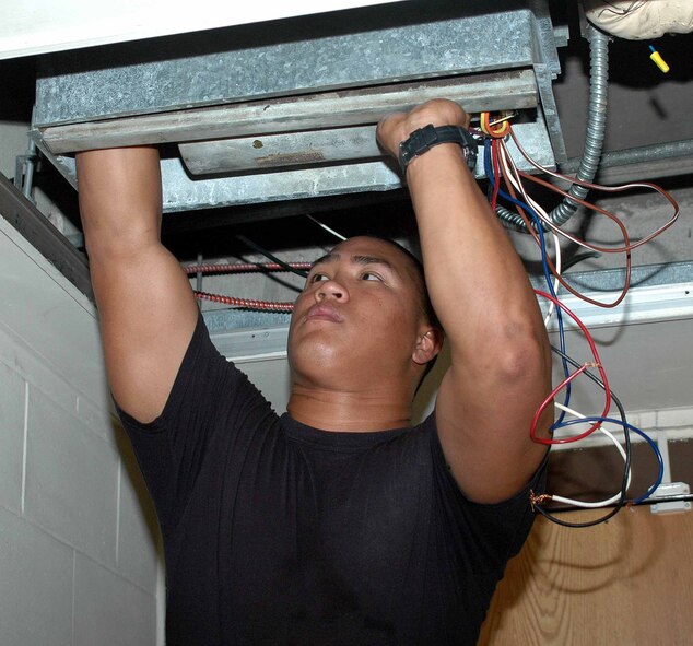 OSAN AIR BASE, Republic of Korea -- Airman 1st Class AinaoKauanoe Emayo, 51st Civil Engineer Squadron Heating, Ventilation, Air Conditioning and Refrigeration technician, replaces a dormitory air conditioning unit July 14. The 51st CES’ HVAC flight has been working 24 hours a day to complete repairs and routine inspections on all Team Osan air conditioning units. (U.S. Air Force photo/Staff Sgt. Candy Knight)