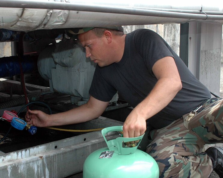 OSAN AIR BASE, Republic of Korea -- Senior Airman Ryan Cummings, 51st Civil Engineer Squadron Heating, Ventilation, Air Conditioning and Refrigeration technician, charges a 30GT compressor July 14 as part of emergency air condition repairs. The 51st CES’ HVAC flight has been working 24 hours a day to complete repairs and routine inspections on all Team Osan air conditioning units. (U.S. Air Force photo/Staff Sgt. Candy Knight)