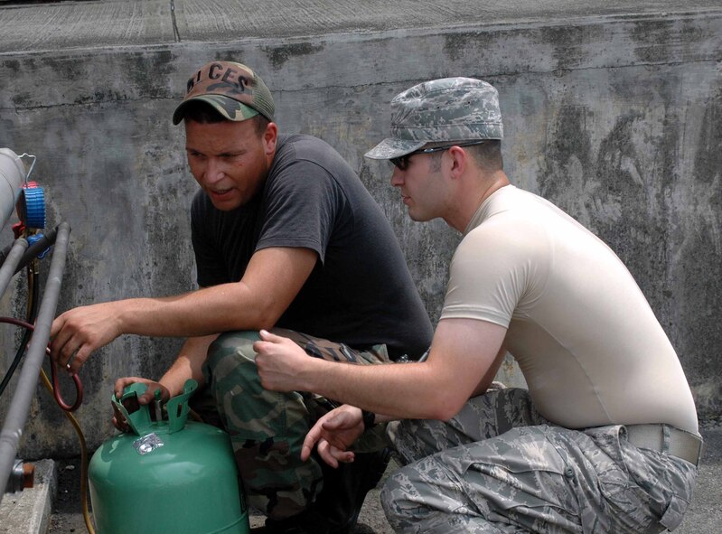 OSAN AIR BASE, Republic of Korea -- Senior Airman Ryan Cummings, (black shirt), and Staff Sgt. Chris Forgey, 51st Civil Engineer Squadron Heating, Ventilation, Air Conditioning and Refrigeration technicians, discuss repairs during an air conditioning maintenance check July 14. (U.S. Air Force photo/Staff Sgt. Candy Knight)