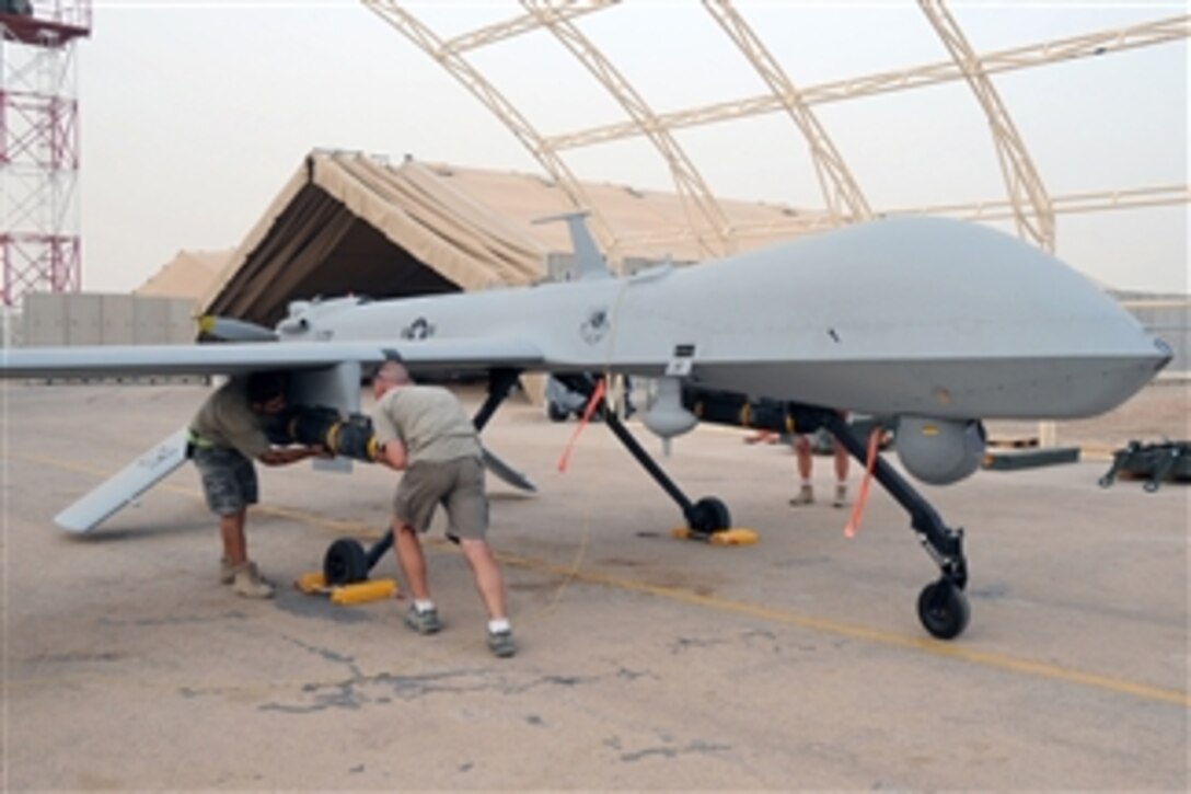 Shilo Thompson and Brandon Walker, both aircraft mechanics with the 361st Expeditionary Reconnaissance Squadron, load an AFM-114 Hellfire missile onto an MQ-1B Predator unmanned aerial vehicle at Ali Air Base, Iraq, on July 9, 2008.  The Predator provides integrated and synchronized close air combat operations for intelligence, surveillance and reconnaissance purposes.  