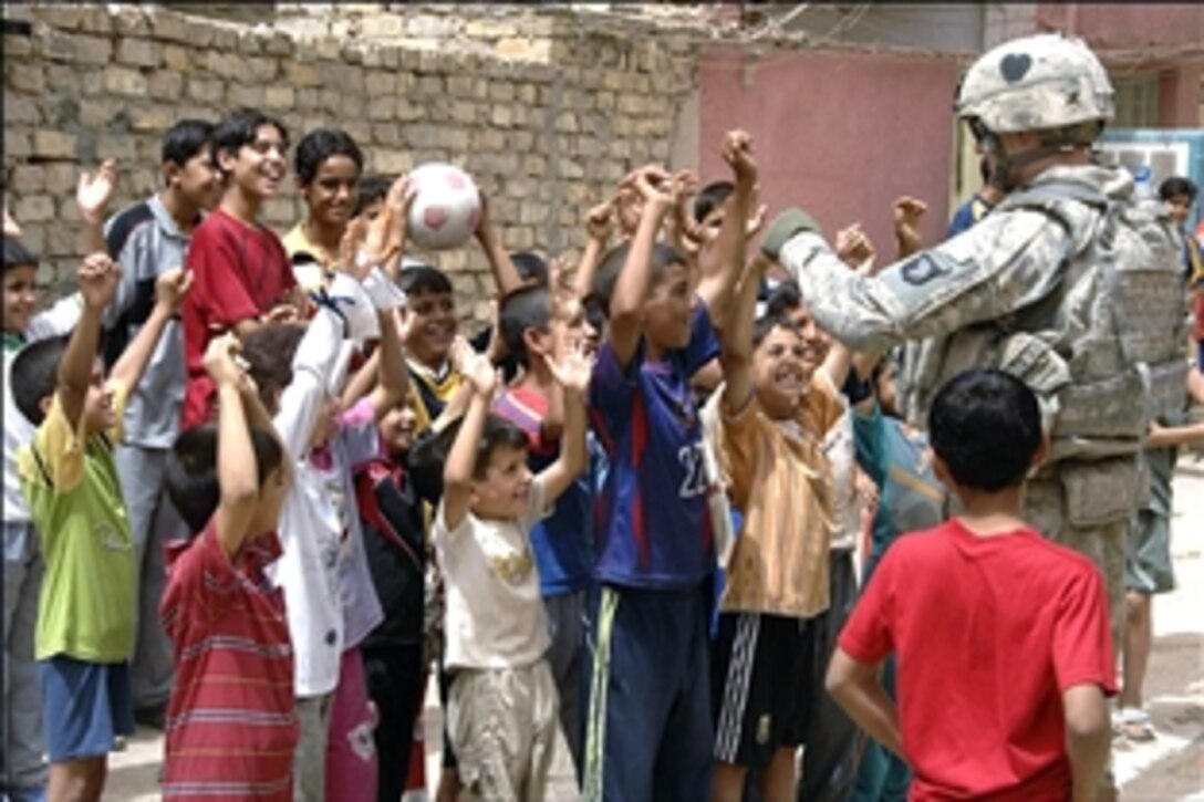 U.S. Army Sgt. Joseph Brumfield plays catch using a soccer ball with local children during a Population Engagement mission in the Shula district, Baghdad, Iraq, July 9, 2008. Brumfield is assigned to the 1st Squadron, 75th Cavalry Regiment, 101st Airborne Division. 