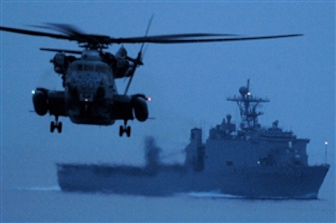 A CH-53E Super Stallion conducts night flight operations near the USS Carter Hall during the Iwo Jima Expeditionary Strike Group composite unit training exercise, COMPTUEX, in the Atlantic Ocean, July 14. 2008. COMPTUEX provides a realistic training environment to ensure the strike group is capable and ready for its upcoming deployment. 