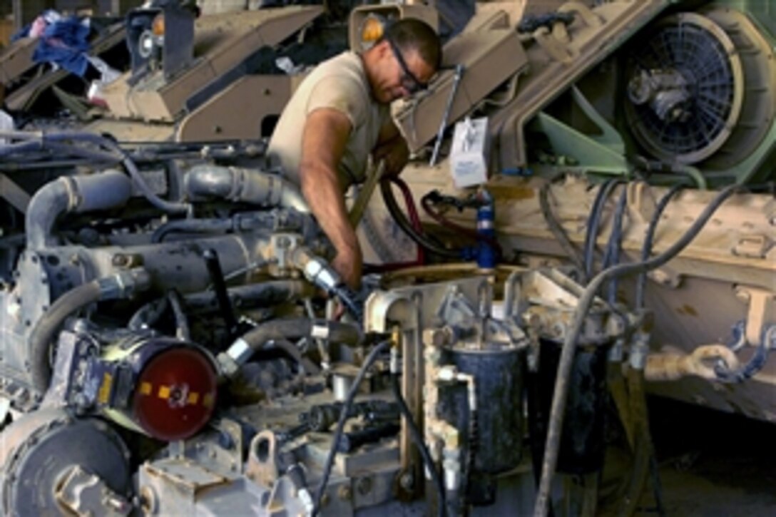 U.S. Army Sgt. Thomas Cosbeeyoma pumps oil into the engine of a Bradley Fighting Vehicle after semi-annual servicing on Combat Outpost Summers, Iraq, July 8, 2008. Cosbeeyoma is a Bradley mechanic assigned to Company B, 2nd Battalion, 6th Infantry Regiment.