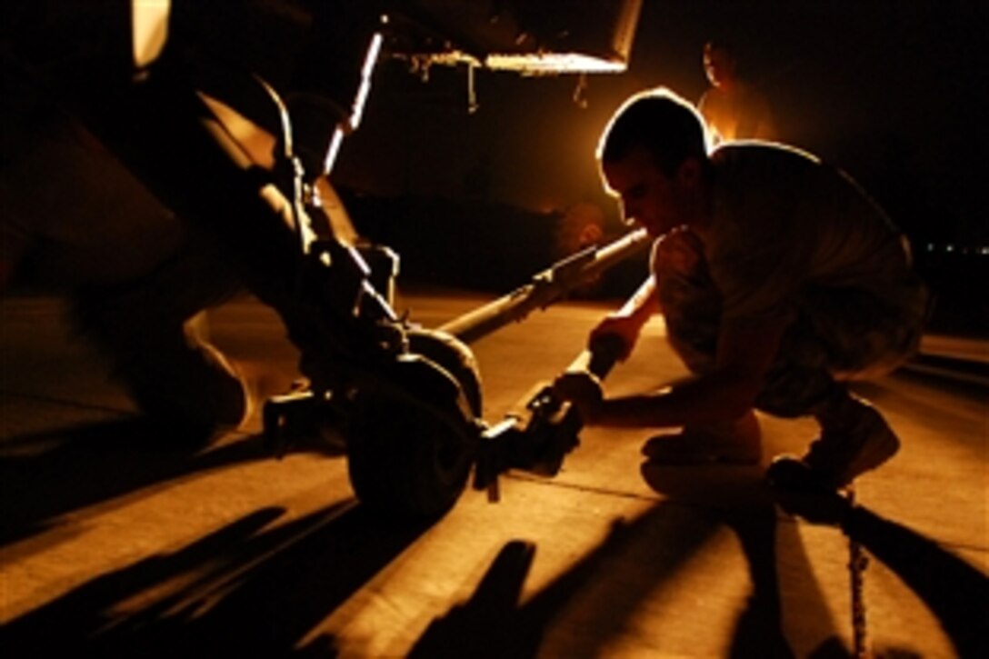 Army Spc. Erik Heath hooks up a toe-bar to the rear wheel of a Black Hawk helicopter, July 12, 2008, at the Combat Aviation Brigade flight line in Baghdad, Iraq. Heath is assigned to 2nd Battalion, 3rd Aviation Regiment.