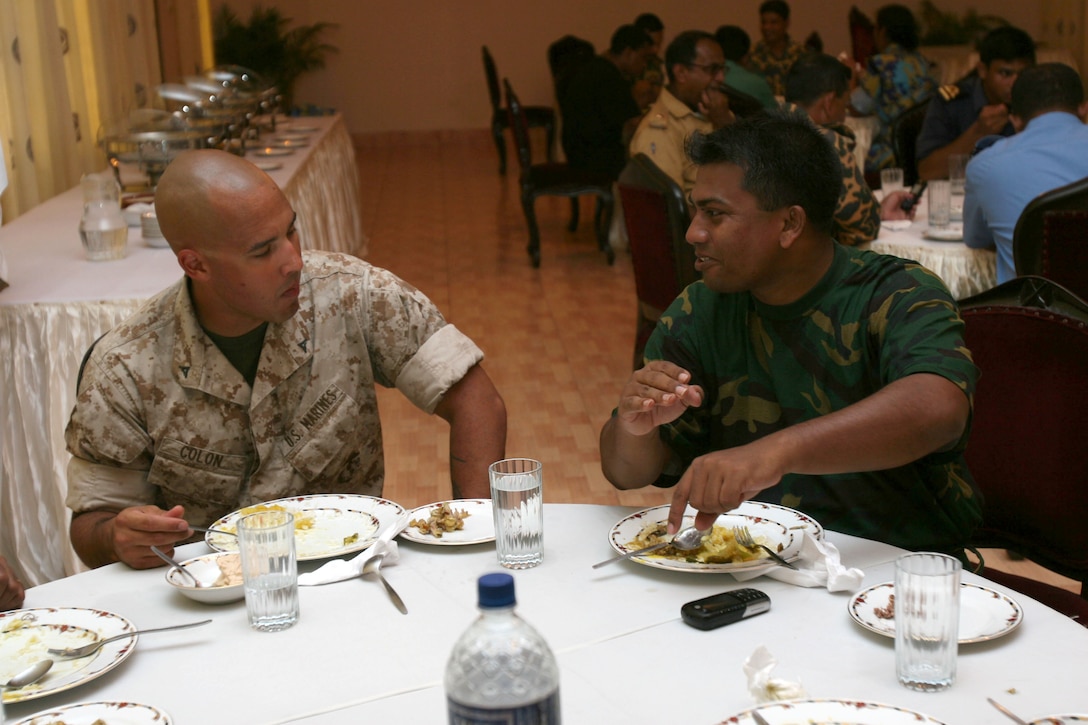Lance Cpl. Jesus Colone (left) and Bangladesh Army Maj. Shahed Minhazsiddiquei discuss American culture   July 16 during Non-Lethal Weapons Executive Seminar 2008 here. Colone is an amorer with III Marine Expeditionary Force Headquarters Group. Minhazsiddiquei is a weapons instructor with the Bangladesh Army School of Infantry.