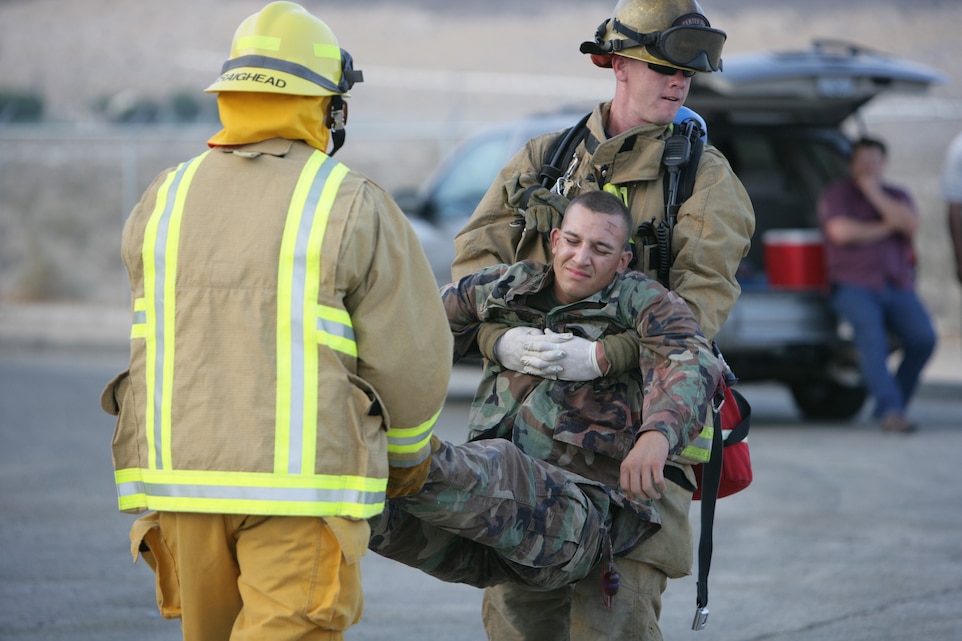Adam Craighead and Jason Swift, Combat Center firefighters, carry a mock casualty away from the scene of an improvised explosive device. This incident was only part of a base-wide anti-terrorism force protection exercise taking place July 14 to 18, 2008. Other base units, like the Explosive Ordinance Disposal team, responded to two reports IEDs.