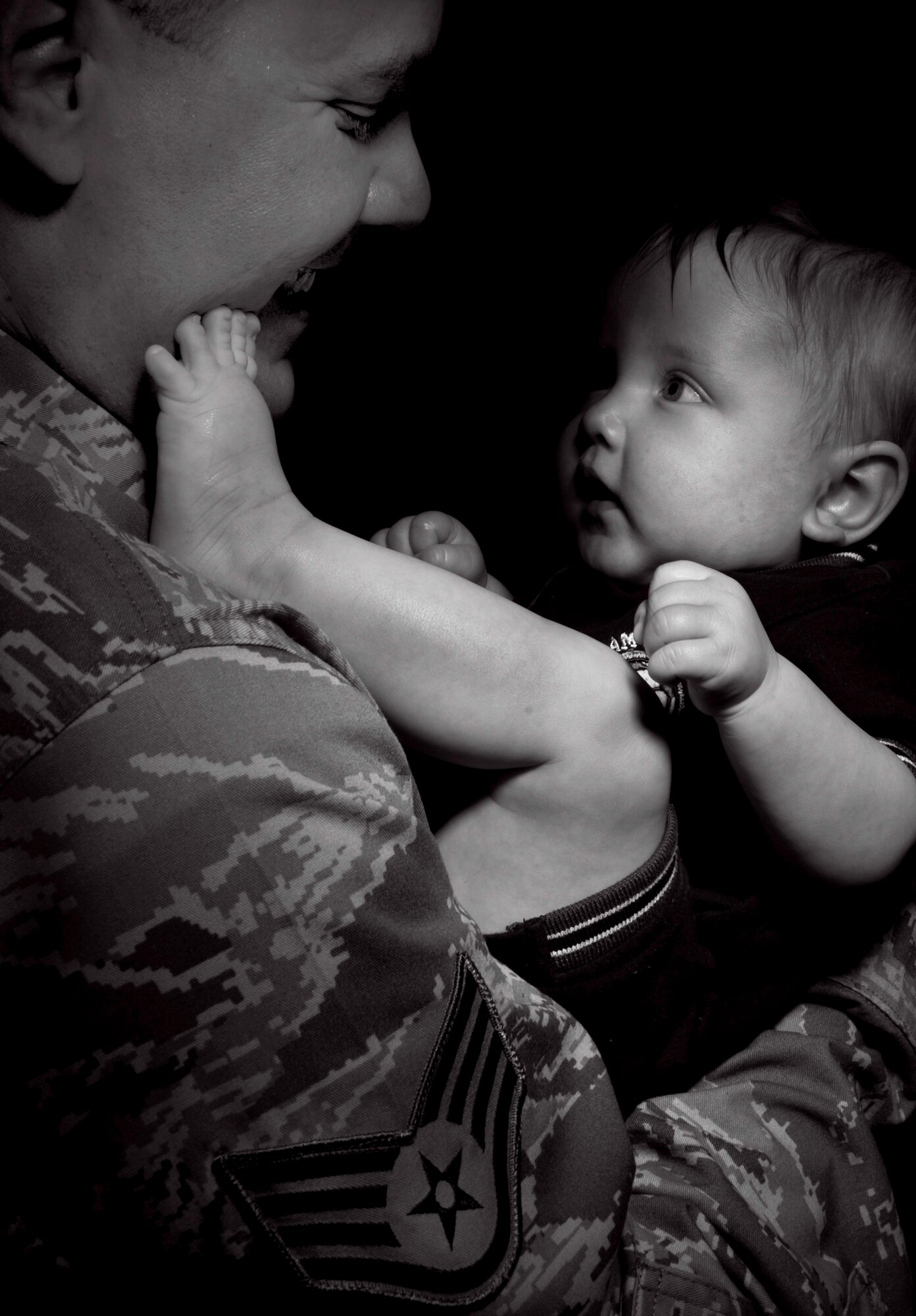The bonding process between child and parent takes place during the early months after a child is born.  This process is sometimes delayed due to many male Airmen who are deployed during the birth of their children. Staff Sgt. Ryan Veith has a playful, bonding moment with his son, R.J. Sergeant Veith missed the birth of his first son due to his deployment to Iraq from September 2007 to February 2008.  Sergeant Veith is a military working dog handler for the 354th Security Forces Squadron Eielson, Air Force Base, Alaska. He has deployed eight times and is set to leave for his ninth deployment in July. 