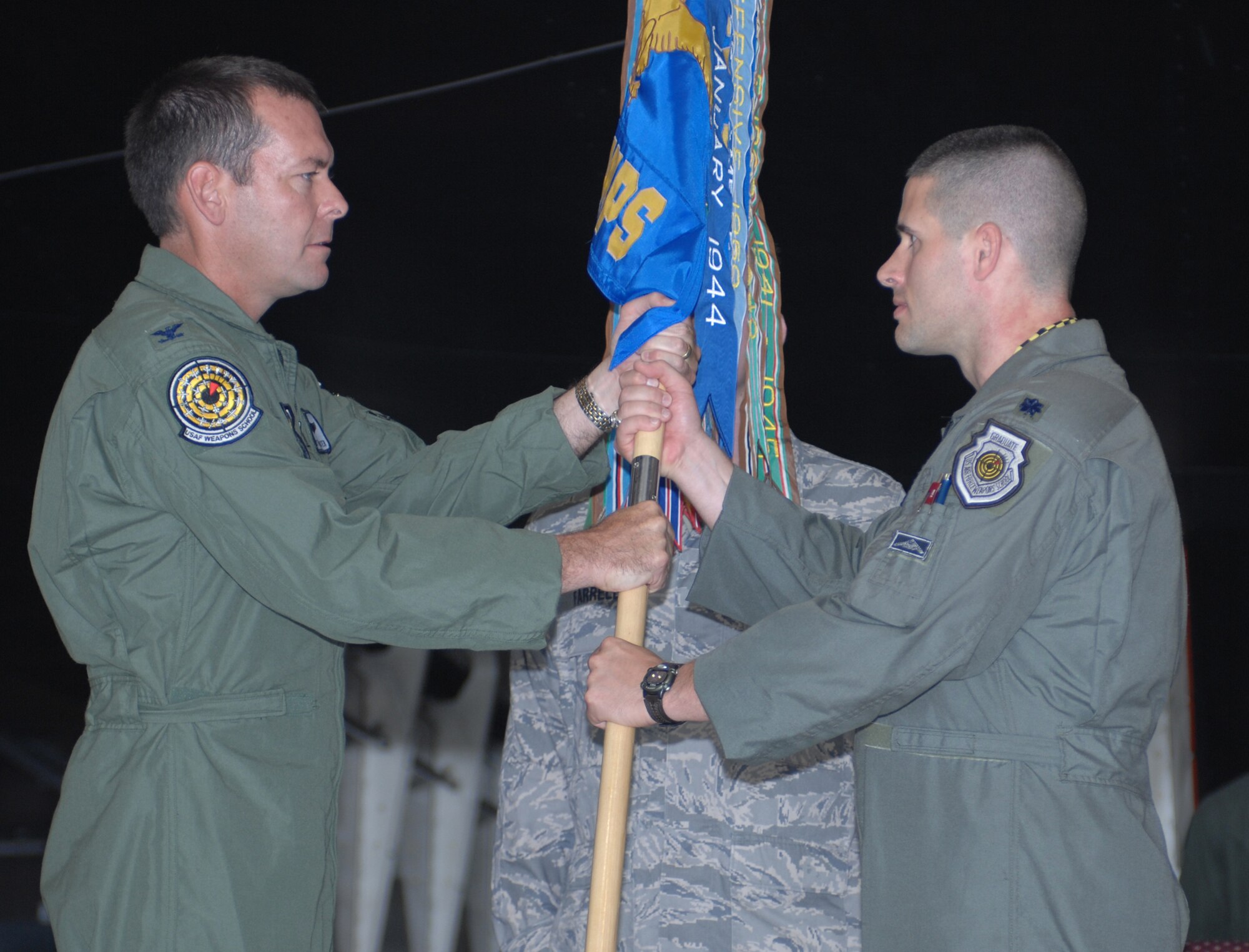 WHITEMAN AIR FORCE BASE, Mo.,- Col. Scott Kindsvater, U.S. Air Force Weapons School commandant, presents Lt. Col. Rodney P. Cousins with the 325th Weapons Squadron guidon during a change of command ceremony here July 11. Colonel Cousins assumed command of the 325th WPS from Lt. Col. Andy Gebara. (U.S. Air Force Photo/Staff Sgt. Charles Larkin Jr.)