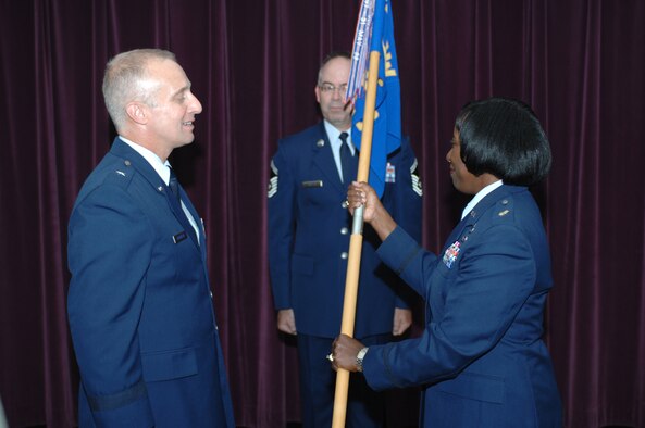 WHITEMAN AIR FORCE BASE, Mo., -- Brig. Gen. Garret Harencak, 509th Bomb Wing commander, presents Maj. Sanora Brunson with the 509th Comptroller Squadron guidon during a change of command ceremony here July 10. Major Brunson assumed command of the 509th CPTS from Lt. Col. Kevin Head. (U.S. Air Force photo/Staff Sgt. Charles Larkin Jr.)