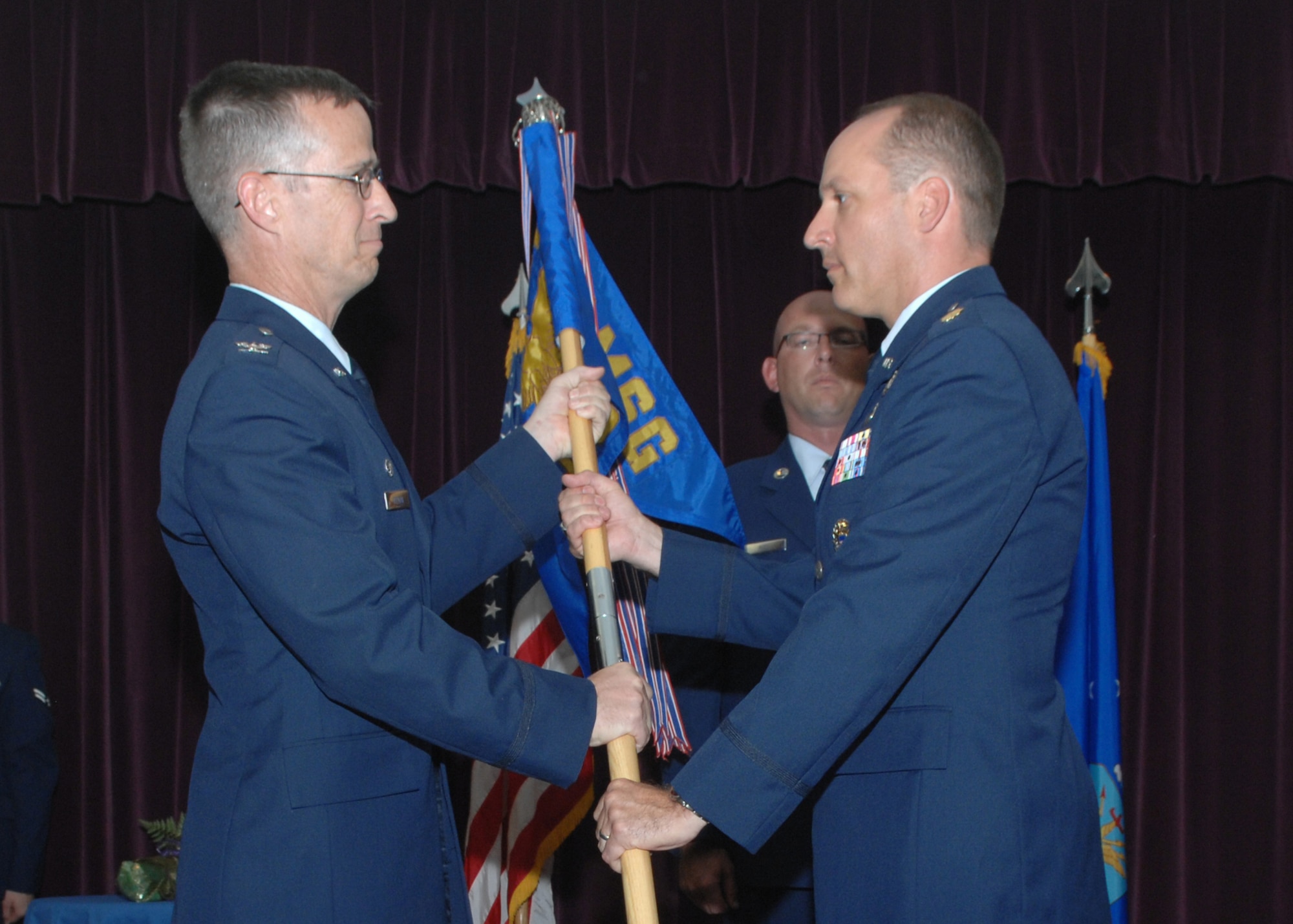 WHITEMAN AIR FORCE BASE, Mo., -- Col. Edward Keegan, 509th Mission Support Group commander hands Maj. Steven Paxton with the 509th Communications Squadron guidon during a change of command ceremony July 9. Major Paxton took command of the 509th CS from Lt. Col. Michael Finn. (U.S. Air Force photo/Staff Sgt. Charles Larkin Jr.)
