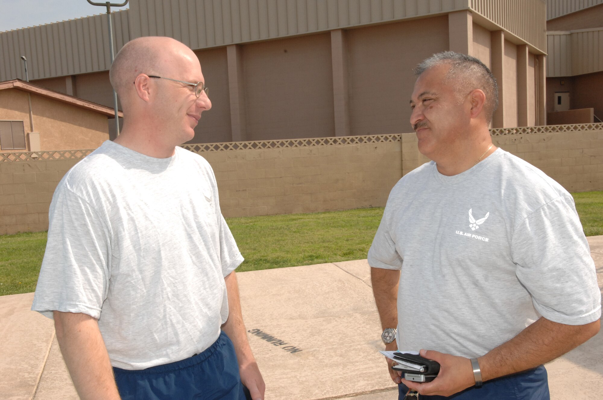 NELLIS AIR FORCE BASE, Nev. -- Major Scott Rider (left), 99th Security Forces Squadron commander, talks with Master Sgt. Rudy Martinez, 99th Security Forces Squadron operations superintendent, during a recent quarterly Security Forces Group competition at the base pool here, July 11, 2008. (U.S. Air Force photo / Senior Airman Kasabyan D. Musal) 