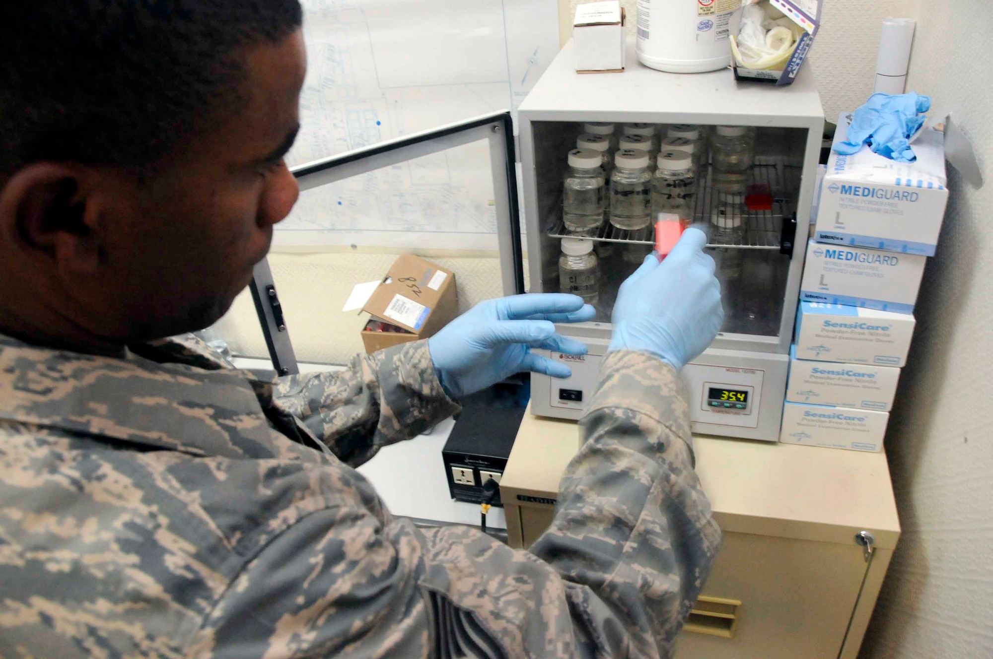 Tech. Sgt. Christopher Hughes, a 379th Expeditionary Medical Group bioenvironmental engineer at an air base in Southwest Asia, places samples of water mixed with sodium thiosulfate into an incubator.  The samples will be heated to 35 degrees Celsius for 24 hours to help identify the presence or absence of coliform bacteria.  (U.S. Air Force photo/Senior Airman Domonique Simmons) 