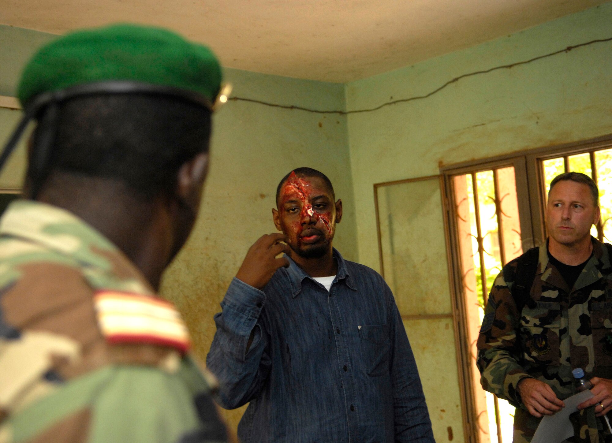 Mohamed Diawara translates for Senior Master Sgt. Robert Traynor while talking to members of the Malian military about the moulage make-up Mr. Diawara is wearing during MEDFLAG 08, July 15. More than 90 servicemembers deployed to Bamako for MEDFLAG 08, a multi-national medical training exercise designed to enhance medical capabilities and readiness for U.S. and African Forces.  Sergeant Traynor is deployed from the 31st Medical Group, Aviano Air Base, Italy. (U.S. Air Force photo/Senior Airman Michael S. Dorus)