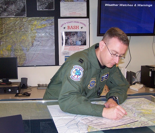 Capt. Chris Strickler, 166th Operations Support Flight, Delaware Air National Guard, the mission planner for the June 7, 2008 five-ship C-130 formation and airdrop mission, documents flight routes in the base operations flight planning room.