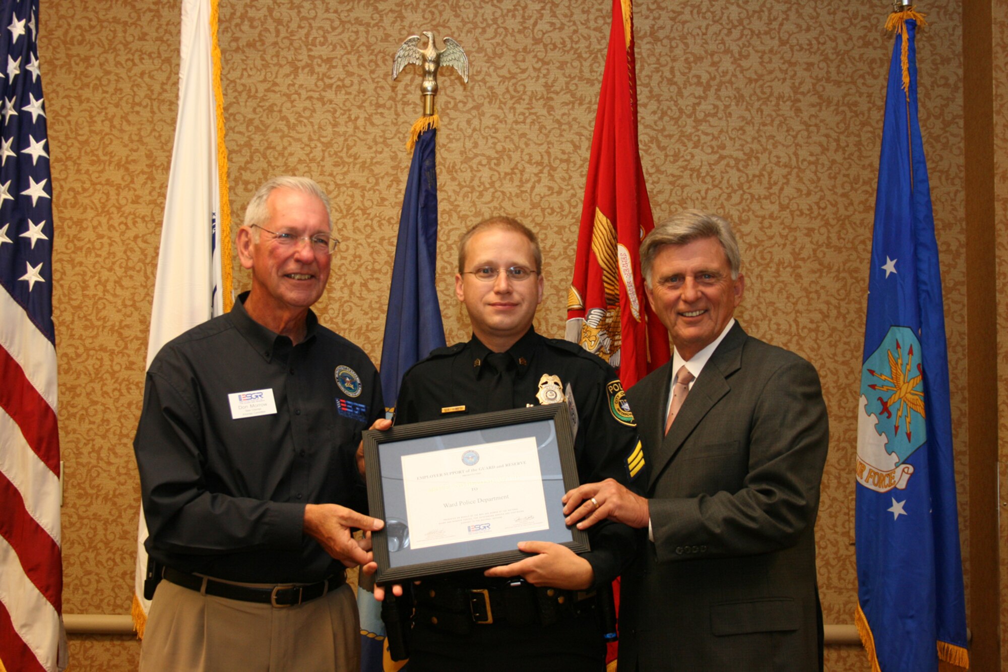 Ward Police Sgt. Eric Sims, accepts an Above and Beyond award from Arkansas Gov. Mike Beebe (right) and retired Maj. Gen. Don C. Morrow, the states Employer Support of the Guard and Reserve chairman. Employers from around the state were recognized July 15 at a ceremony in Little Rock. (Photo by Master Sgt. Bob Oldham)