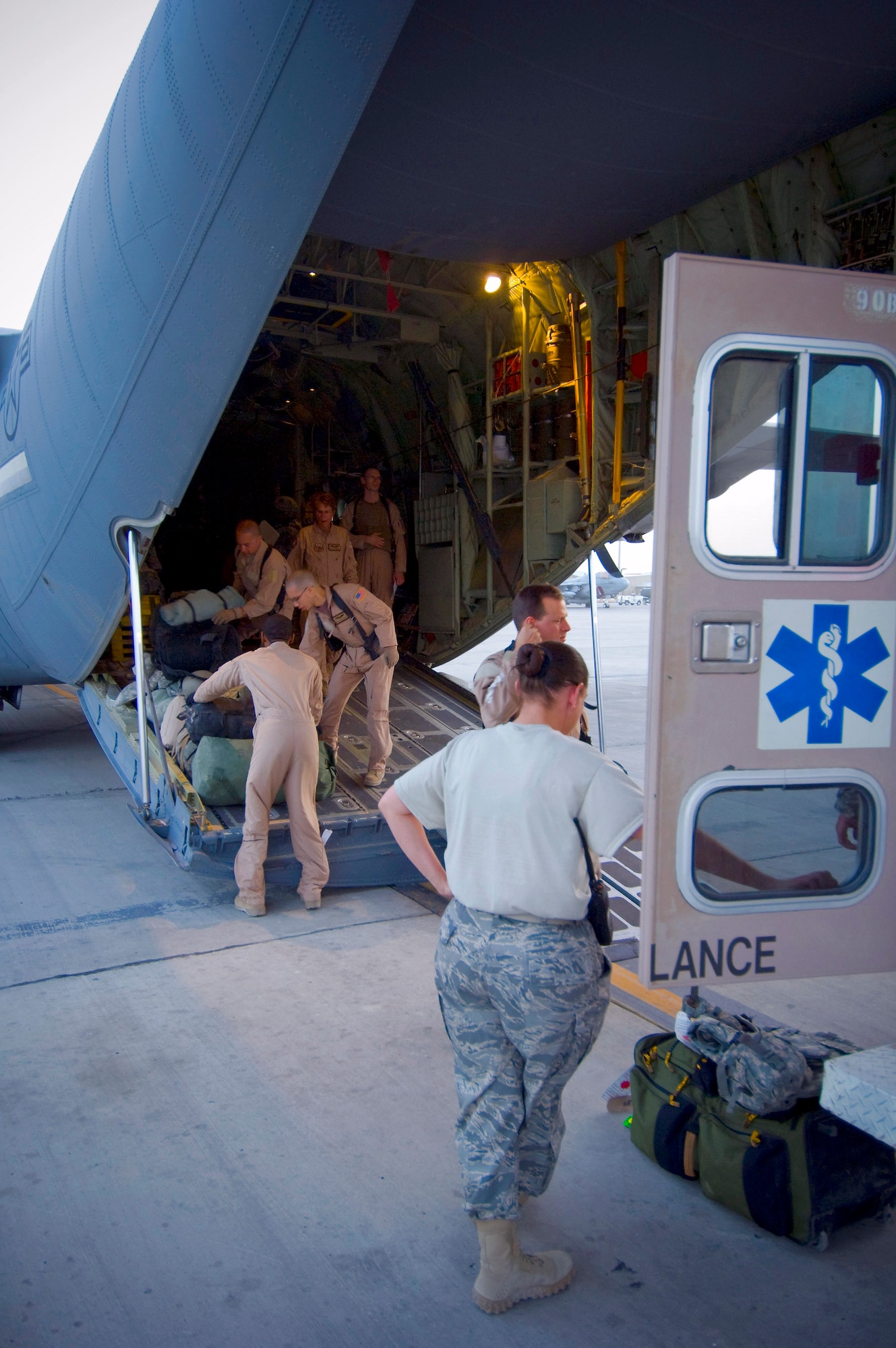 Members of the 455th Expeditionary Aeromedical Evacuation Flight unload a C-130 Hercules July 8 at Bagram Air Field, Afghanistan. The team facilitated the transportation of four patients requiring medical attention to the hospital at Bagram Air Field. All five members of the team are deployed from the 375th Aeromedical Evacuation Squadron at Scott Air Force Base, Ill. (U.S. Air Force photo/Staff Sgt. Samuel Morse) 