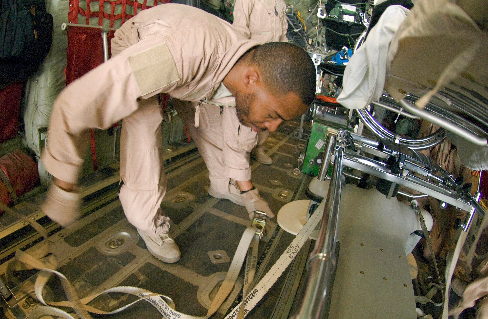 Staff Sgt. Elliot Dozier secures tie-downs to a stryker frame on a C-130 Hercules July 8 at Bagram Air Field, Afghanistan. The stretcher was the final piece of equipment needed to convert the C-130 for aeromedical evacuation operations. Sergeant Elliot is deployed to the 455th Expeditionary Aeromedical Evacuation Flight from the 375th Aeromedical Evacuation Squadron at Scott Air Force Base, Ill. (U.S. Air Force photo/Staff Sgt. Samuel Morse) 