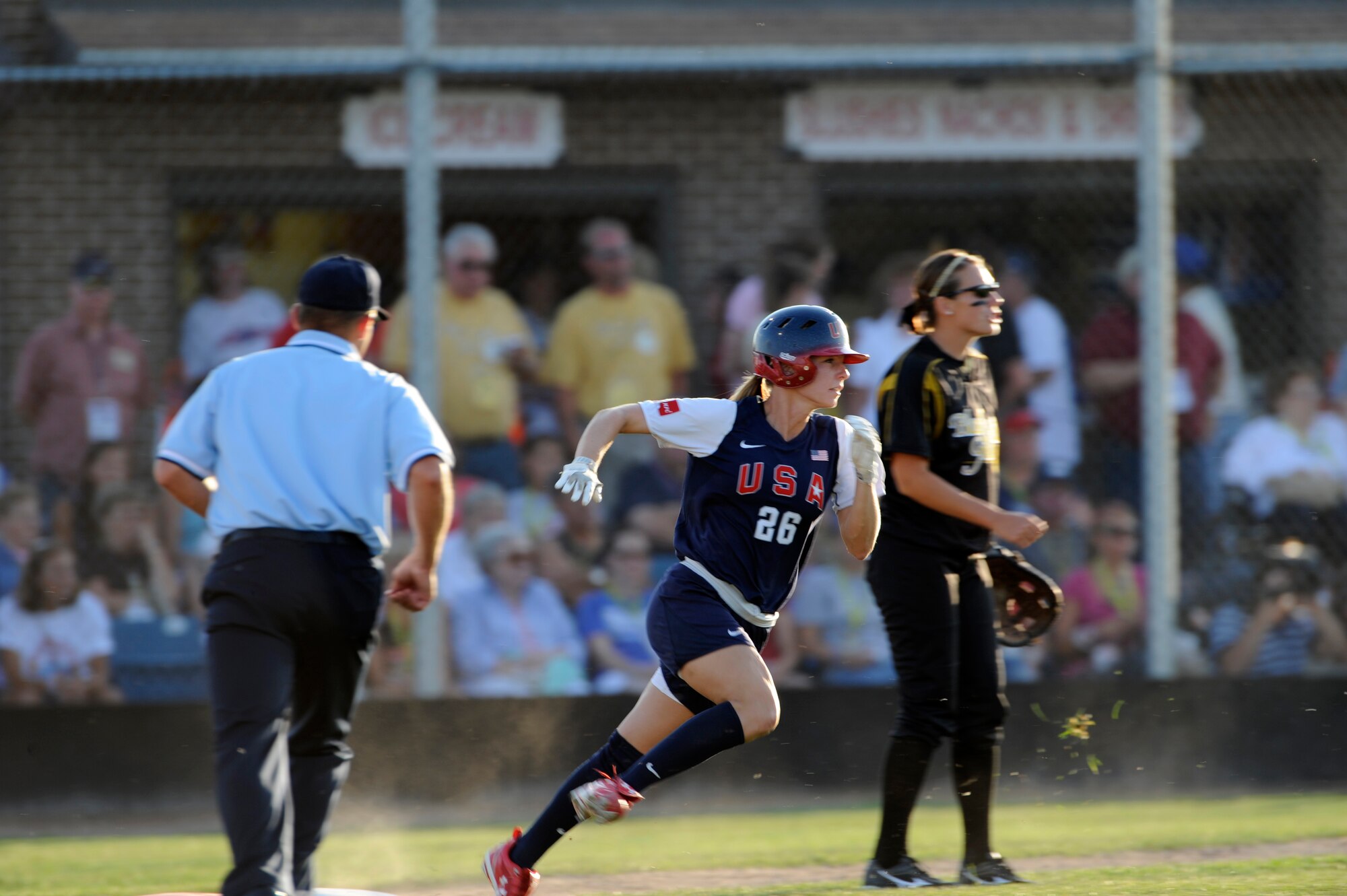 Caitlin Lowe (center), U.S.A. Olympic Softball team outfielder, rounds first base and heads to second legging out a double at the Pete Lien Memorial Field, Rapid City, S.D., July 15. More than 200 fans attended the game. (U.S. Air Force photo/Senior Airman Kasey Zickmund)